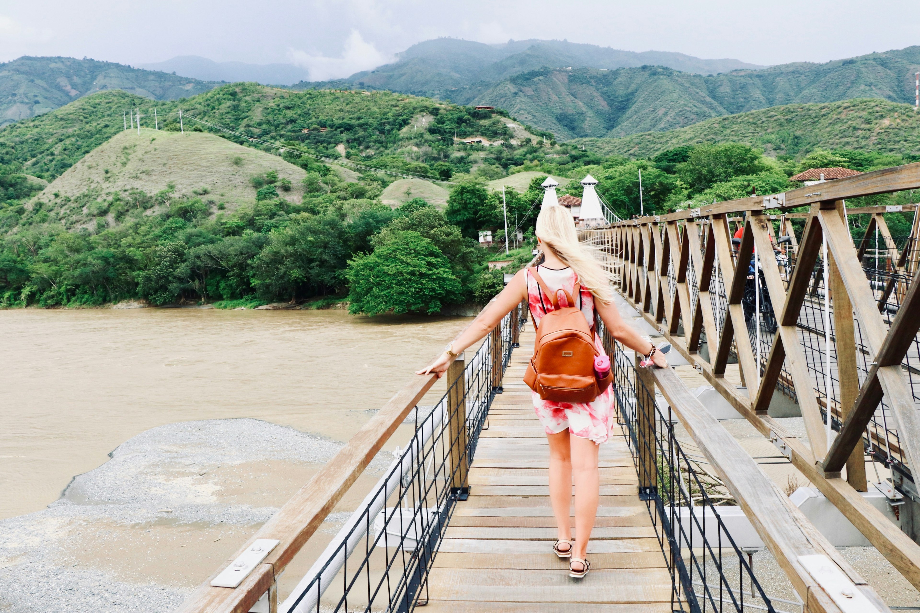 Woman walks across a bridge in the wind in Medellín, Colombia