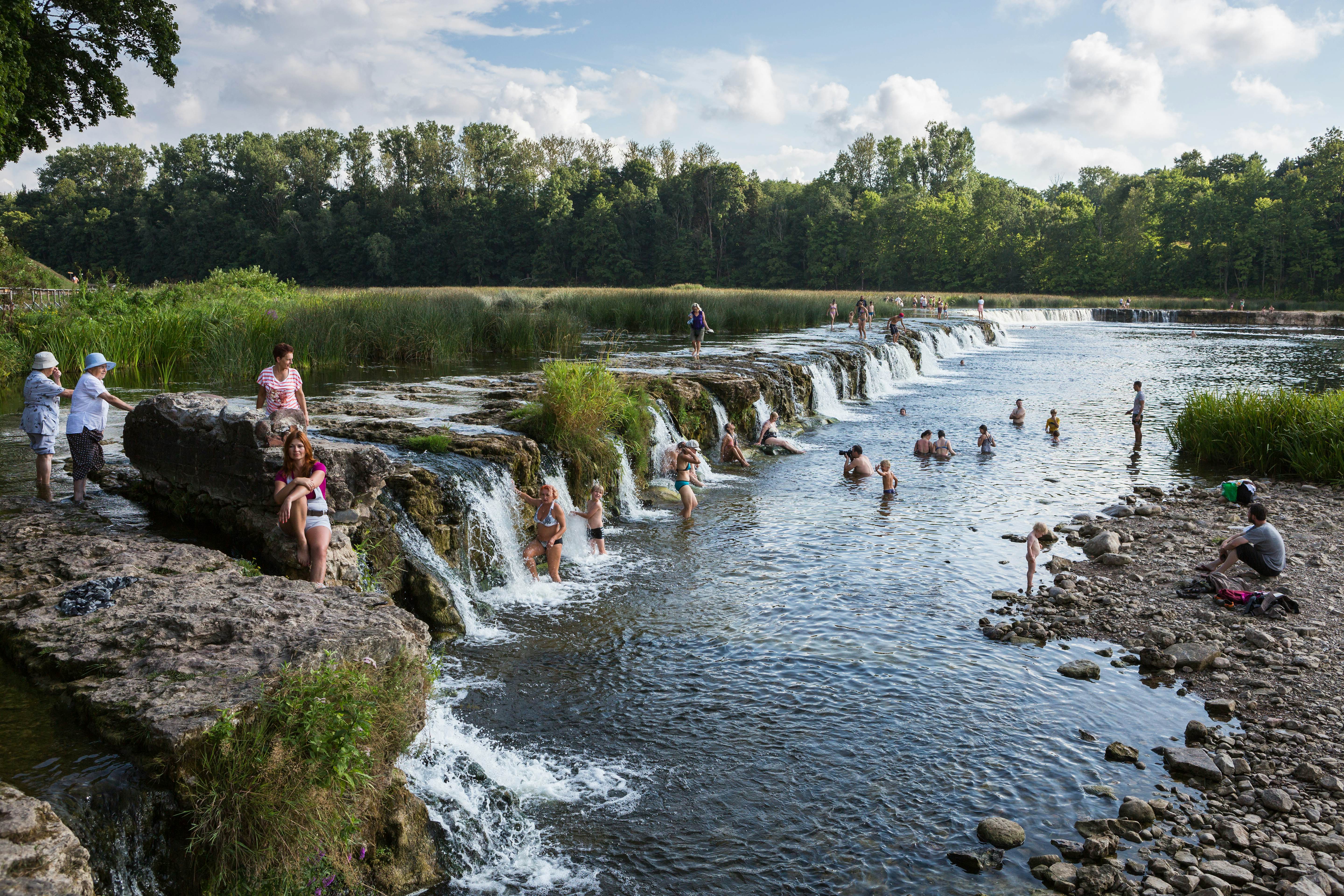 People swimming by the Ventas Rumba watergall in Kuldiga, Latvia.