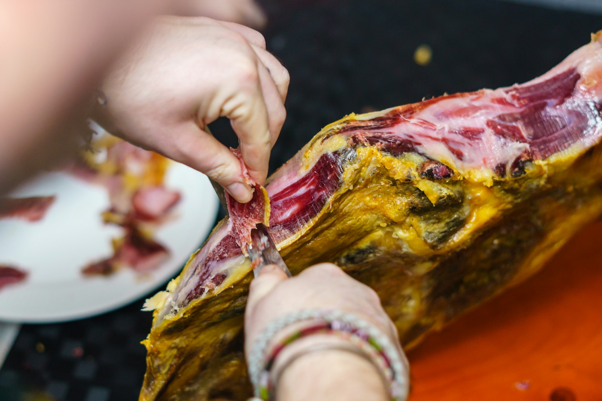 Cutting Spanish acorn-fed Iberian jamón ham with a sharp knife, Spain