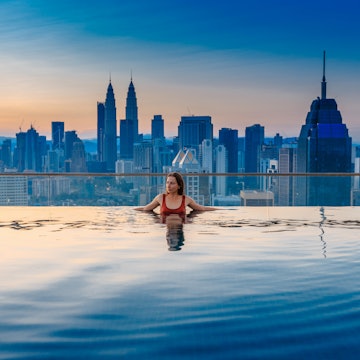 Rooftop swimming pool with the Kuala Lumpur city skyline in the background.