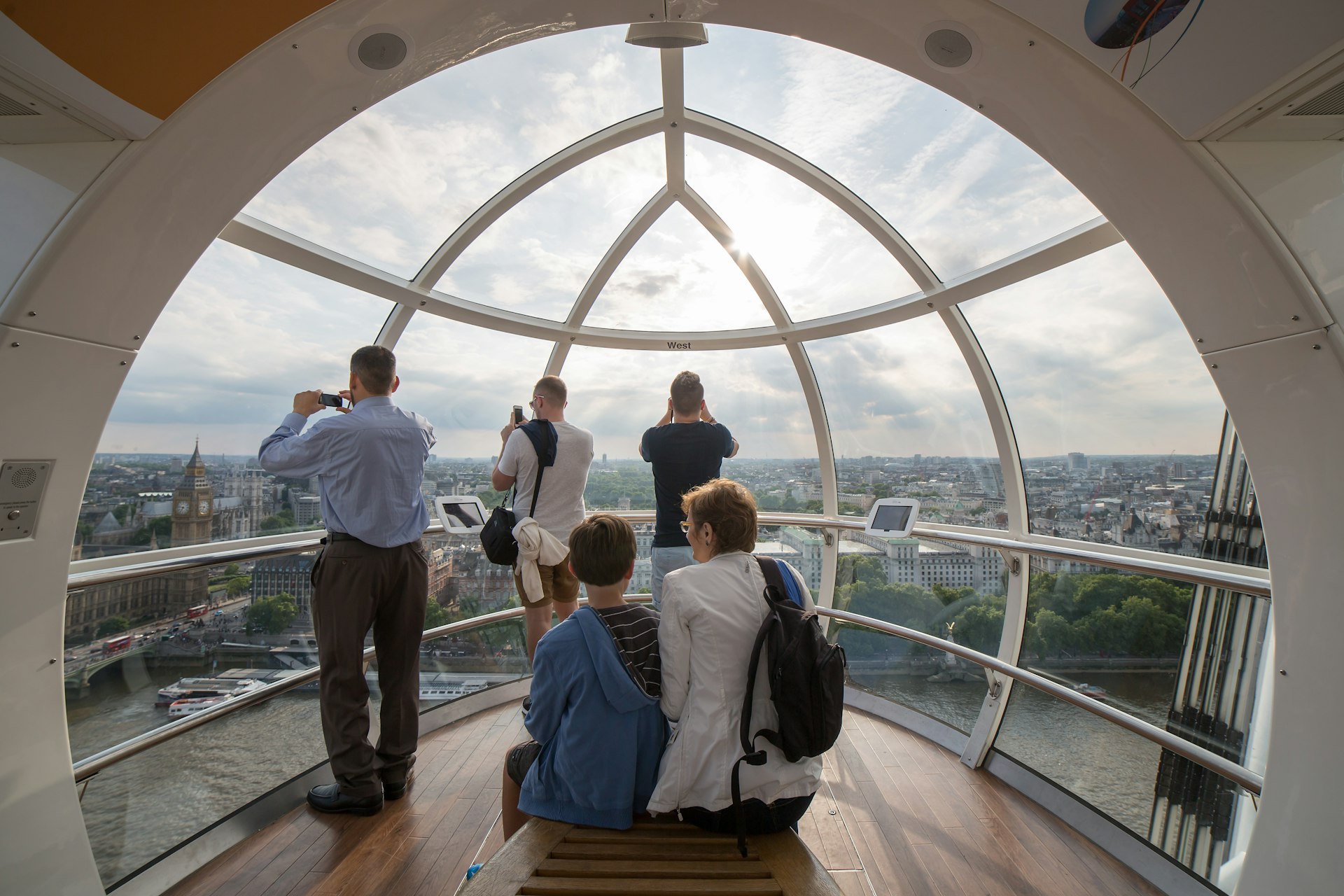 Visitors take pictures of London inside a London Eye capsule.