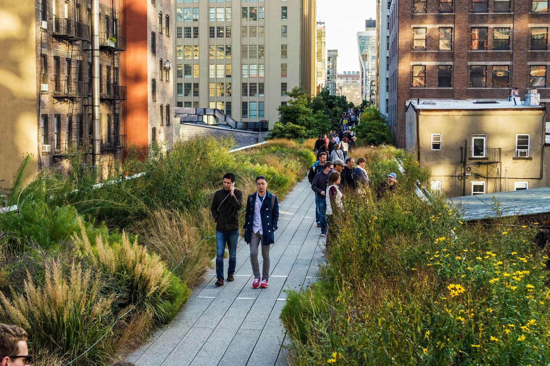 Visitors walking on the High Line, an elevated park in NYC