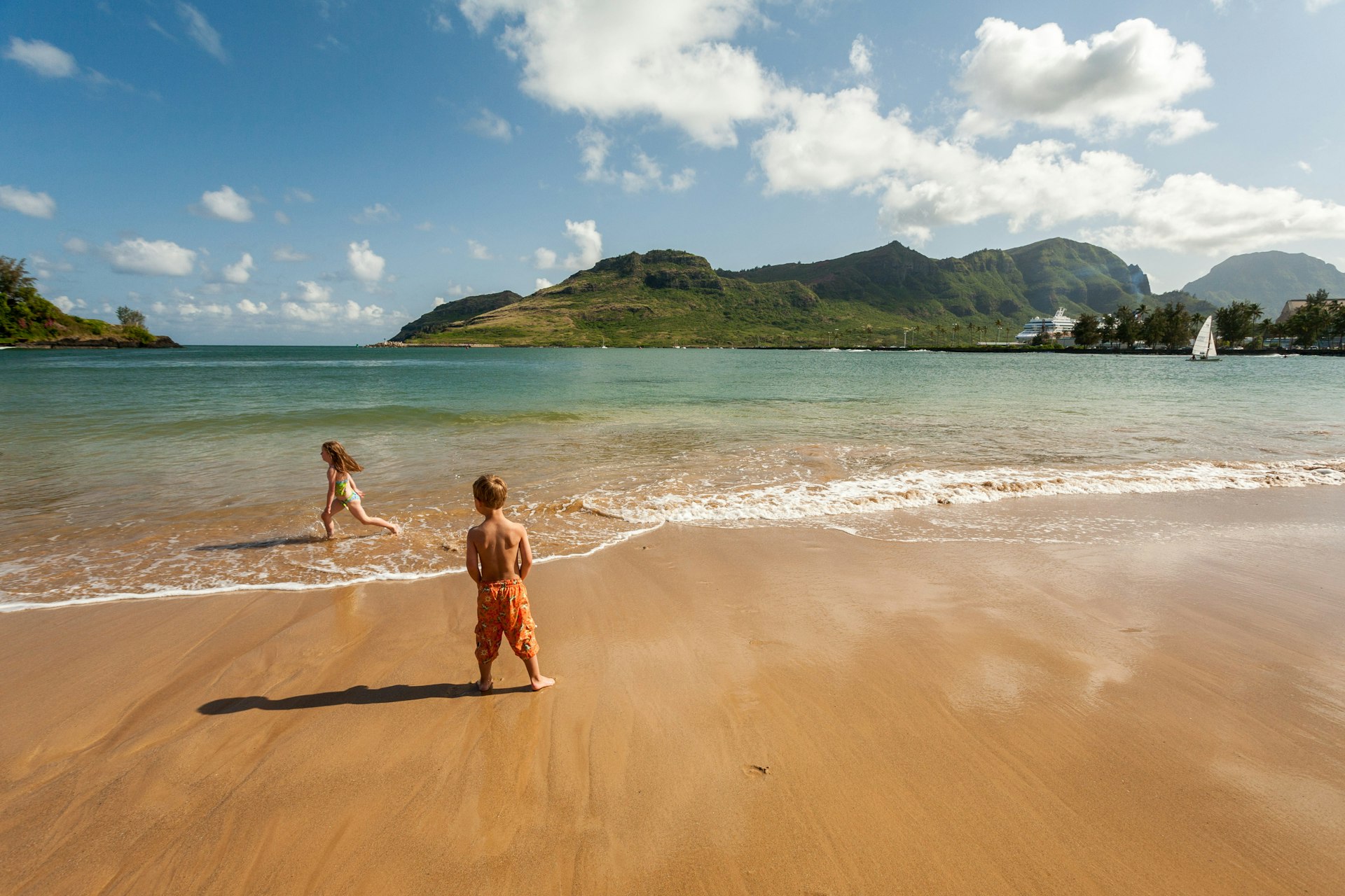 Young children run & play in the waves on Kalapaki Beach near the Kauai Marriott Resort