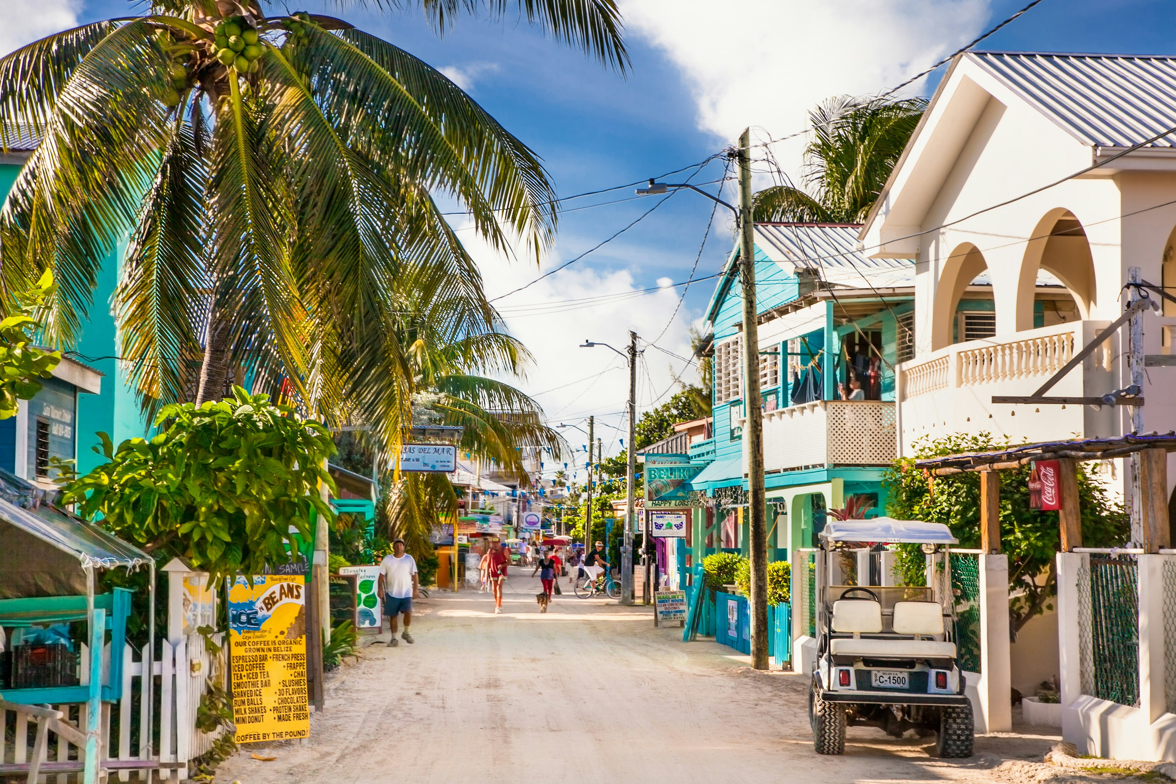 People walk down a dusty street on a car-free tropical island