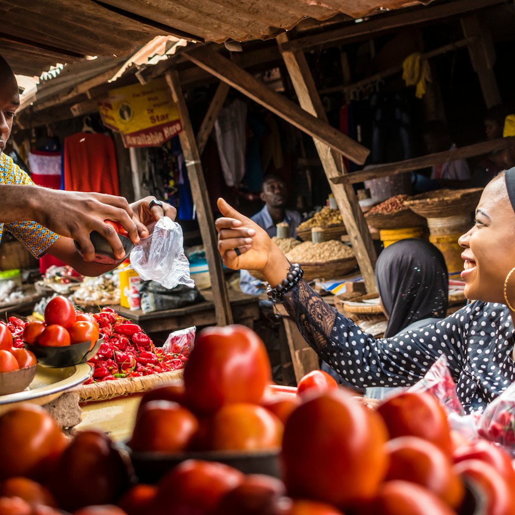 a guy selling tomatoes to a girl in a typical local african market; Shutterstock ID 1107623456; your: ClaireN; gl: 65050; netsuite: Online ed; full: Nigeria things to know
1107623456