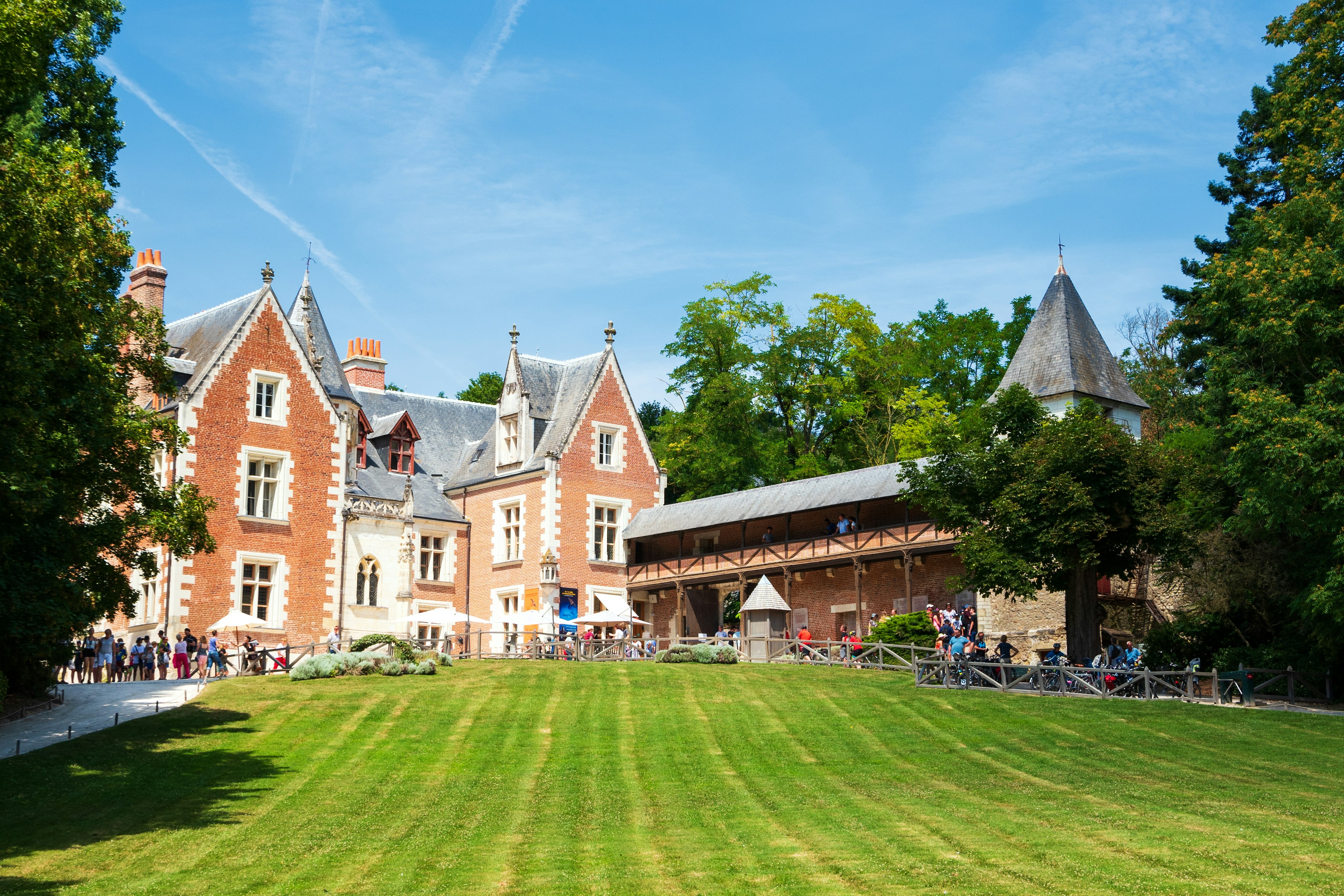 A large red-brick building with guests touring the vast landscaped grounds