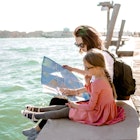 mom and daughter watching a paper map sitting on the edge of The Venetian canal in the summer; Shutterstock ID 1341474437; your: Tasmin Waby; gl: 65050; netsuite: Online Editorial; full: Demand project / Venice with kids
1341474437