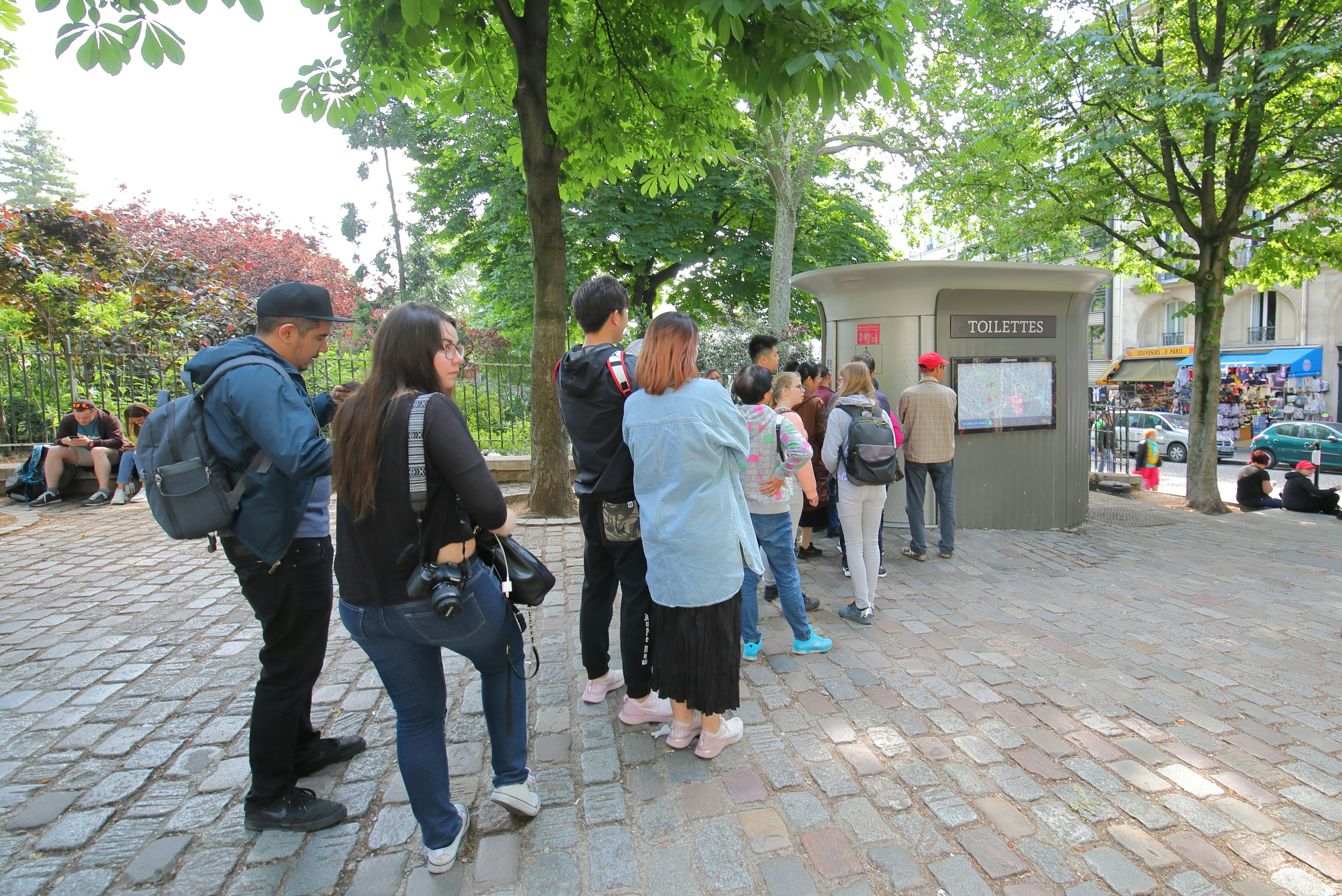 Unidentified people queue for public “Sanisette” toilet on a street in Paris, Île-de-France, France