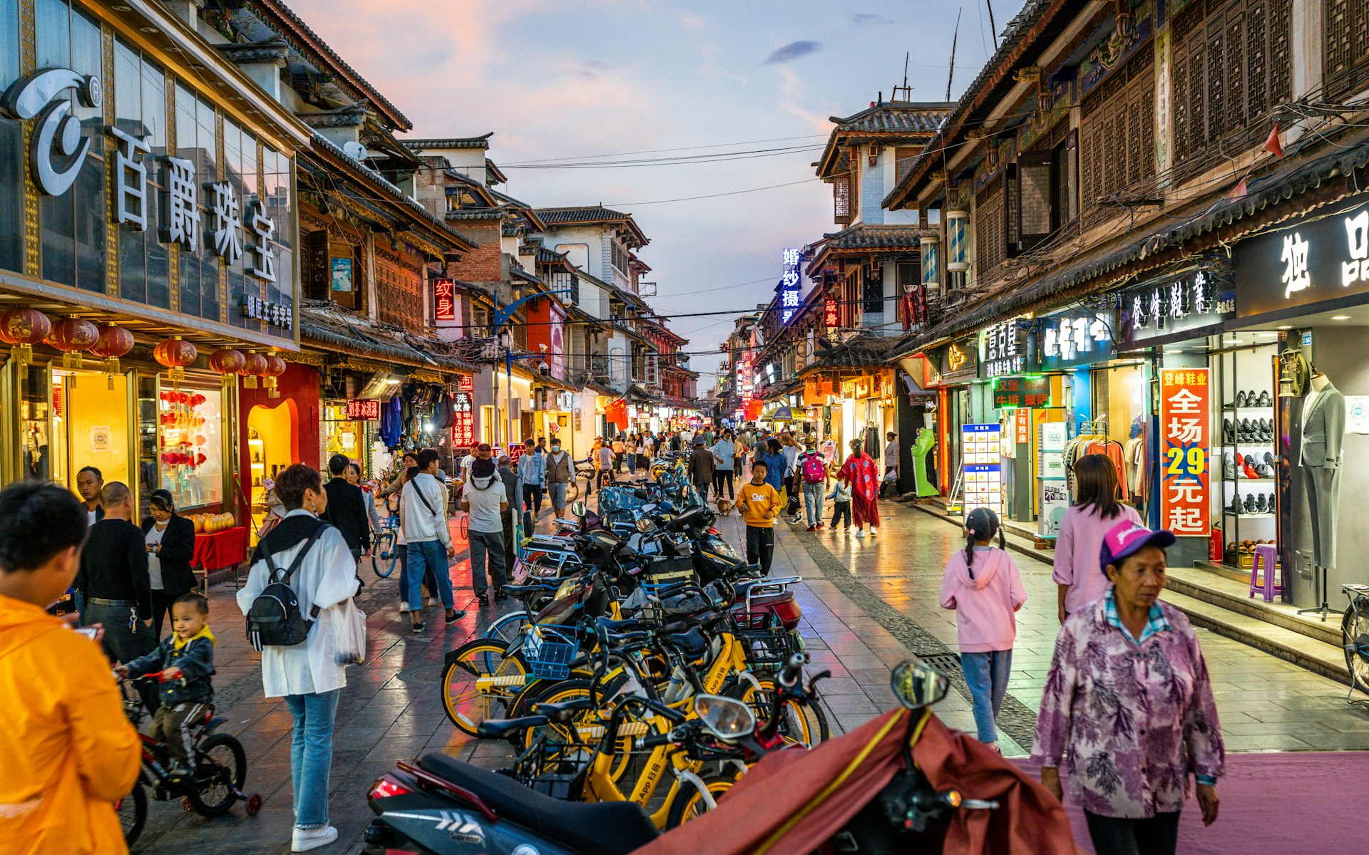 A view of crowds at dusk on a busy street in Guandu, Kunming, Yunnan, China