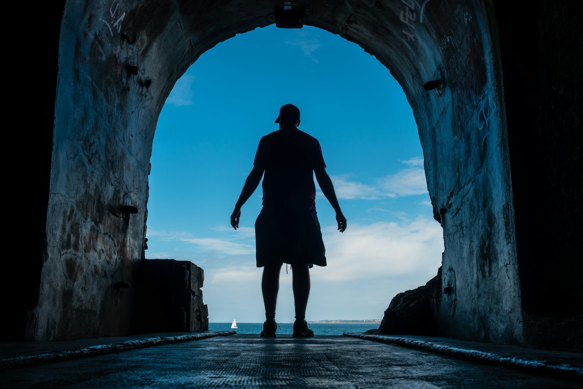 A young man in the tunnel to the sea at the Fort des Capucins a rocky islet located in the Atlantic Ocean, Roscanvel, on the Crozon peninsula in France