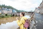 Young woman in yellow raincoat traveling with backpack and photo camera in Dinan village at Brittany region in France; Shutterstock ID 667908934; your: Tasmin Waby; gl: 65050; netsuite: Online Editorial; full: Brittany TTD
667908934