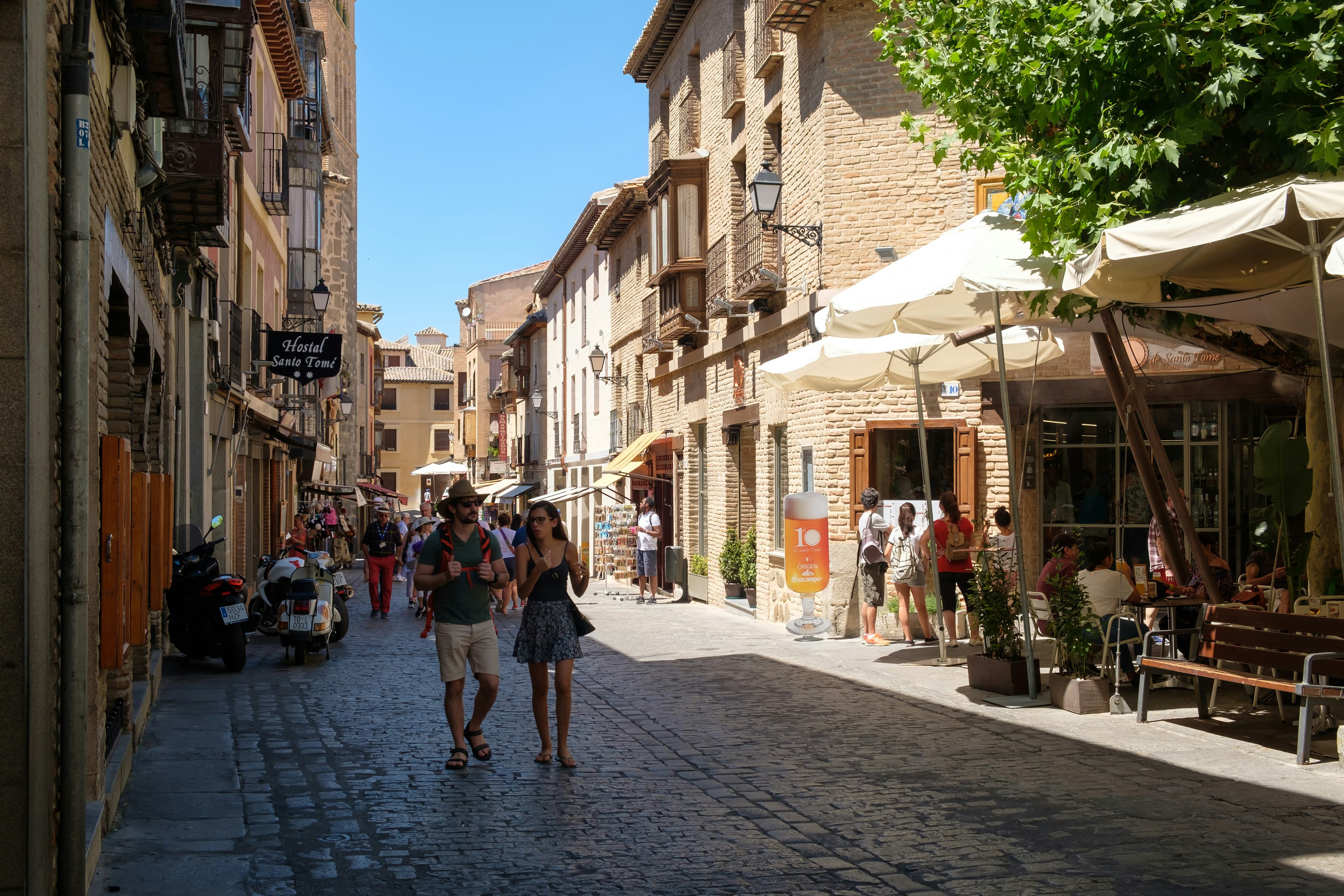 People walking down a cobbled street in the medieval city of Toledo