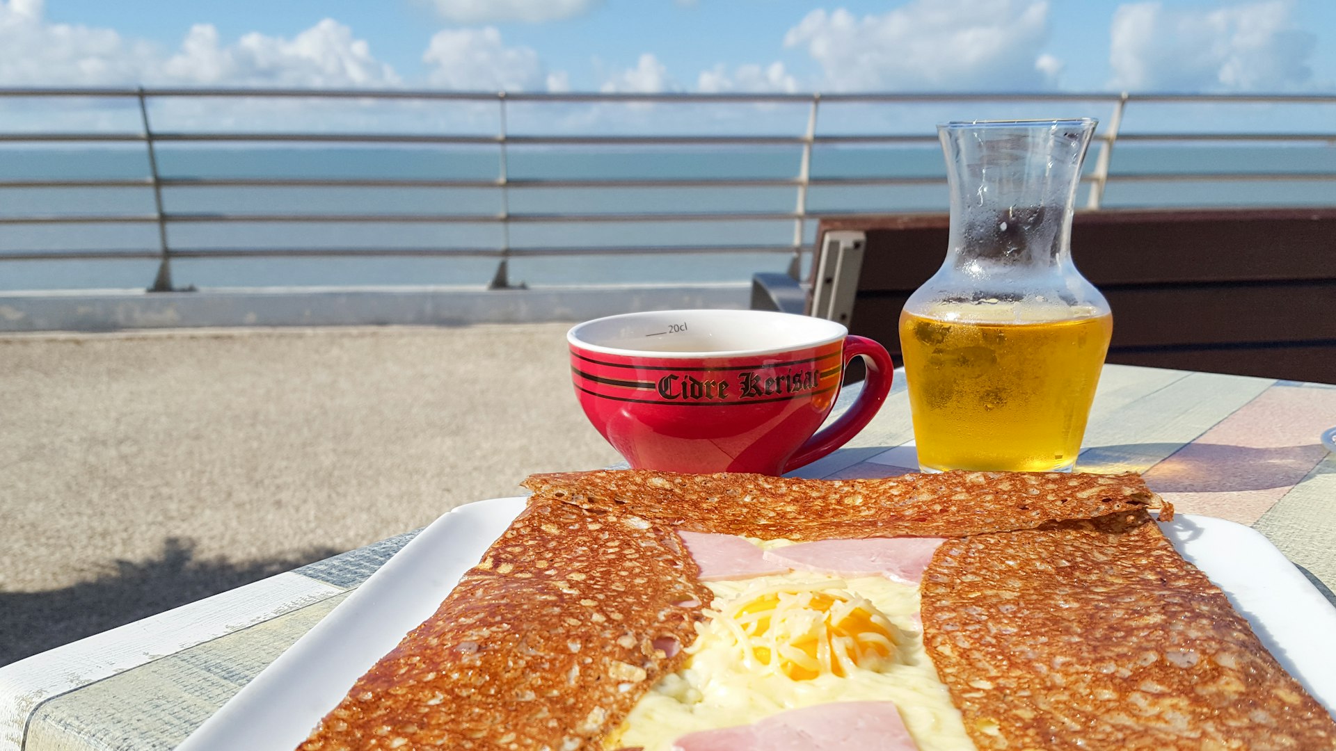  kerisac red bowl of cider with locale typical french Breton crepe complete on restaurant terrace sea side brittany; 