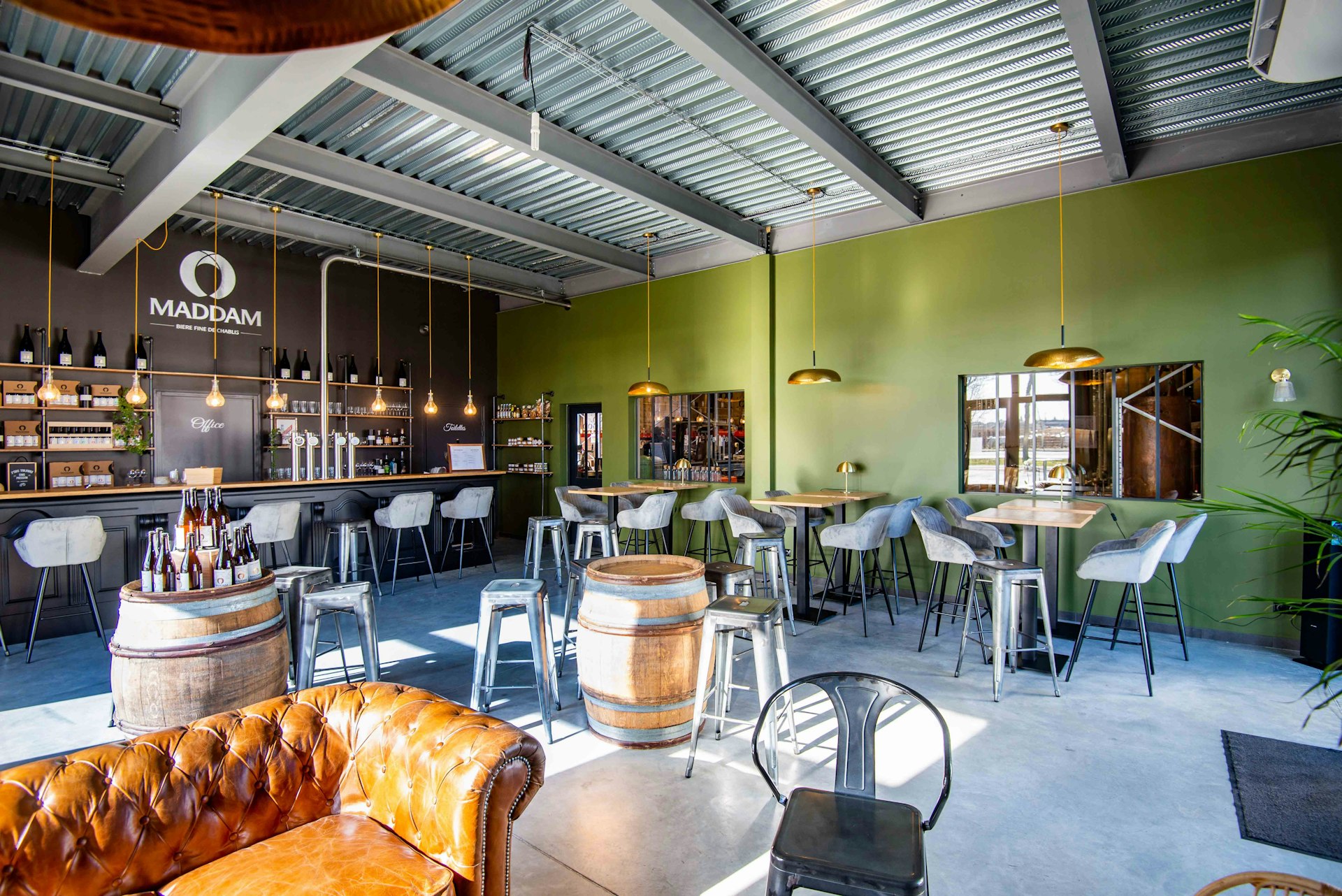 The interior of a sleek and modern microbrewery with seating for visitors. 