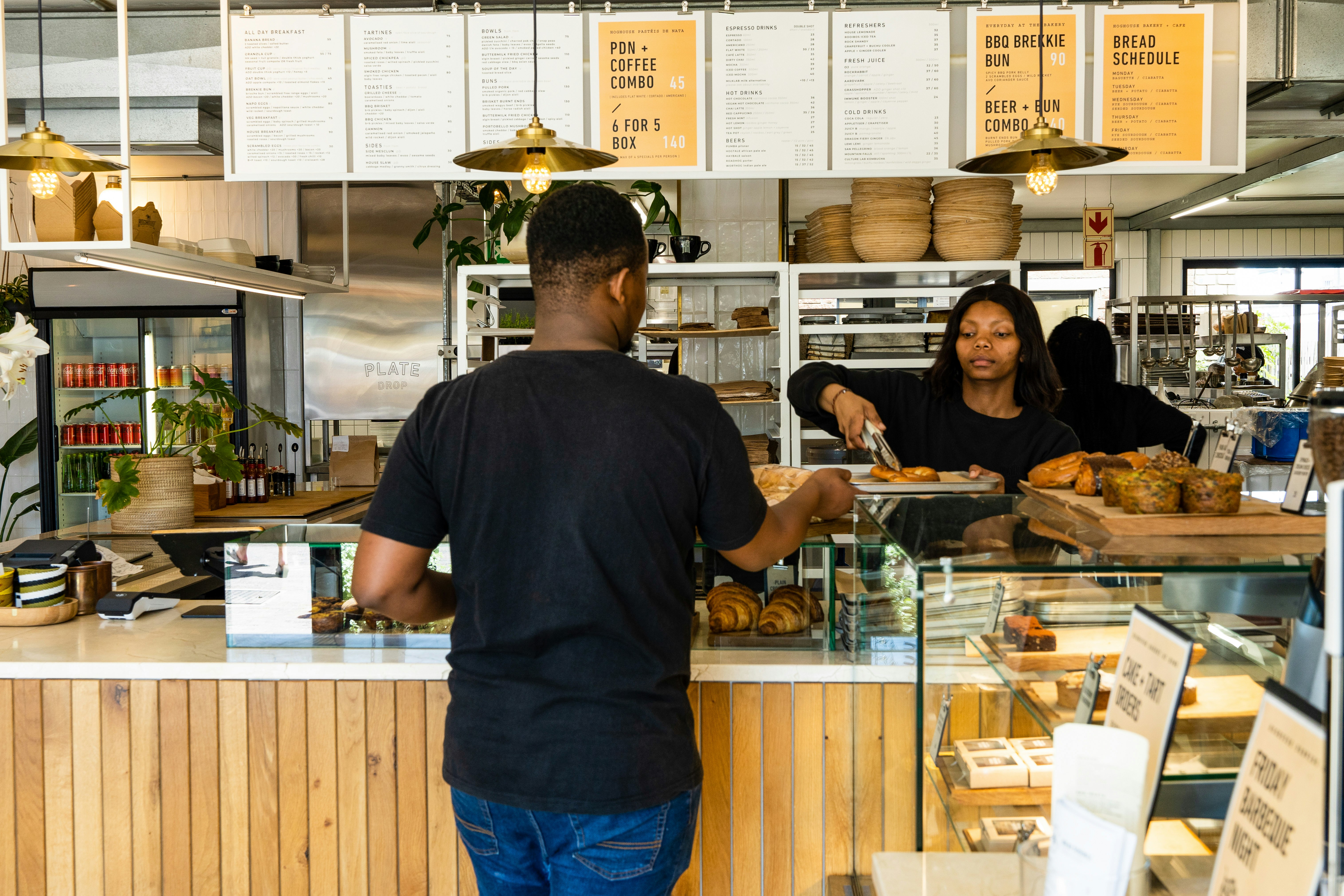 A woman serves a man at the Hoghouse Bakery in Cape Town, South Africa