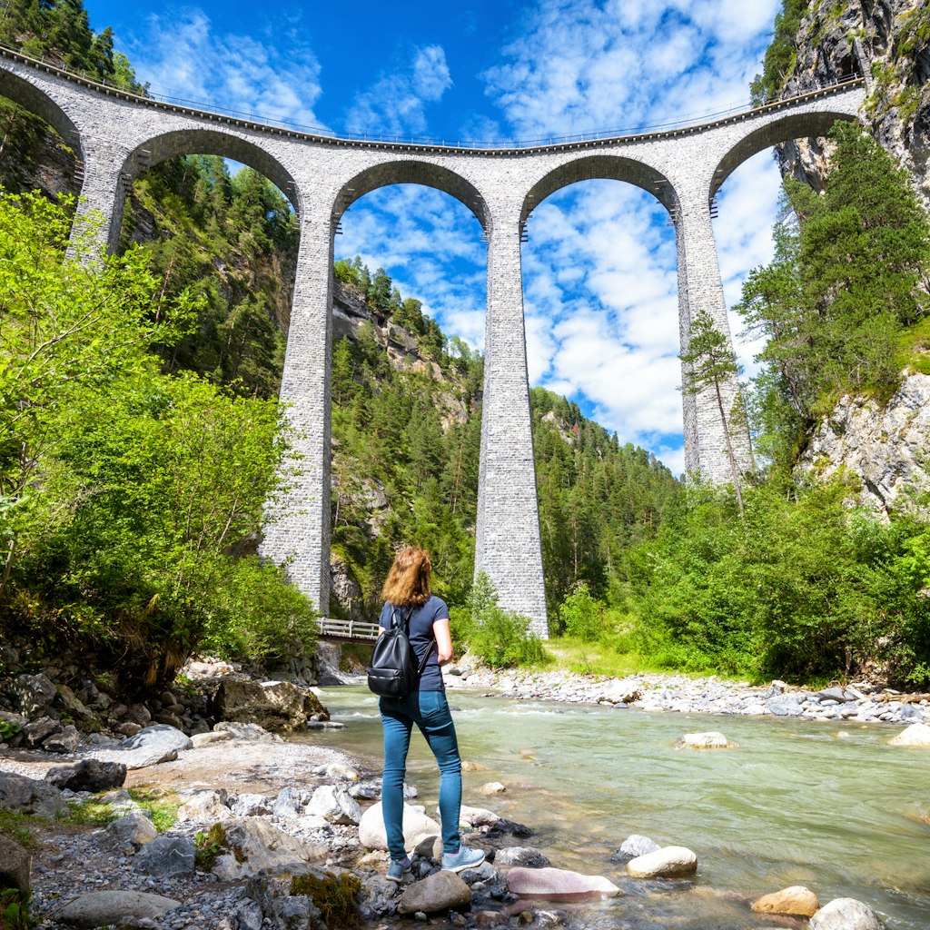 Landwasser Viaduct in Filisur, Switzerland. Young woman looks at the famous tourist attraction. Scenic panorama of high railway bridge in mountains. Adult girl travels in Swiss Alps in summer.
1176201948
rhaetian, landwasser, filisur, express, bernina