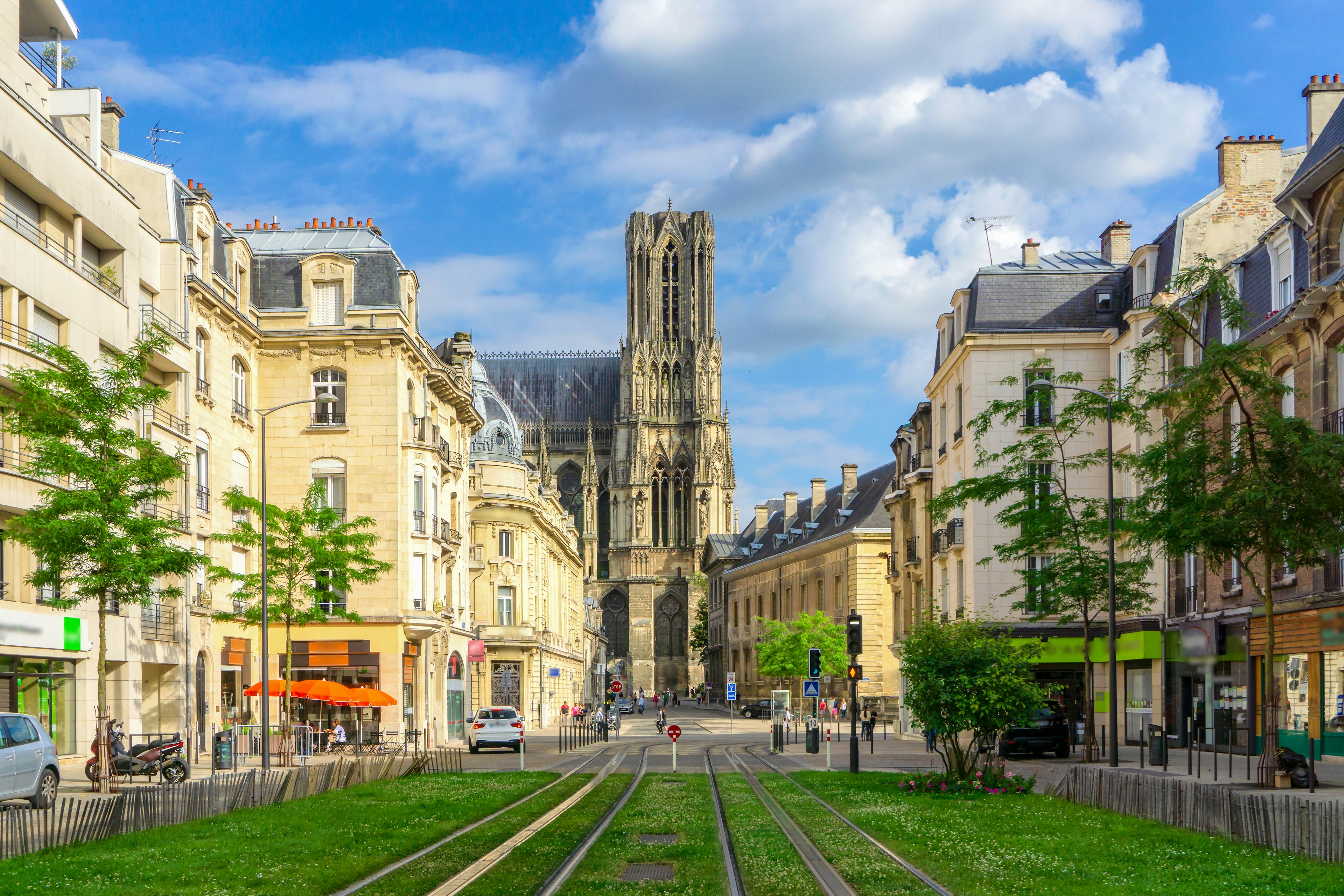 Tram lines lead towards a cathedral in a city