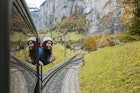 happy smiling woman looks out from windows traveling by train on most picturesque train road in Swiss
1197623028