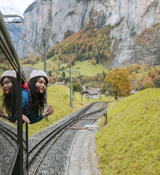 happy smiling woman looks out from windows traveling by train on most picturesque train road in Swiss
1197623028