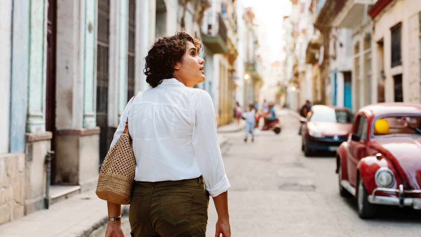 Cuban girl walking down street in Havana, exploring the city with curiosity
1456178960