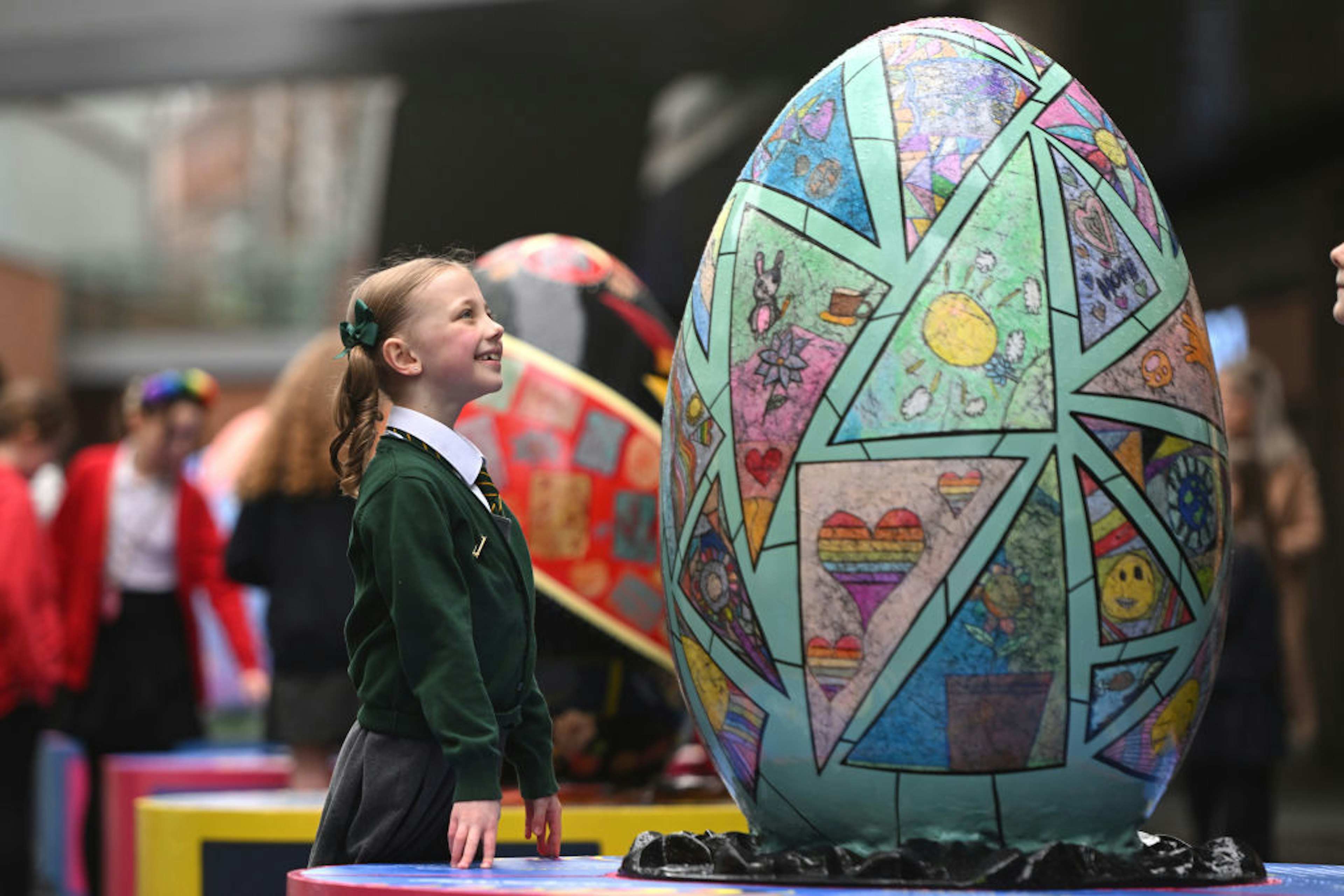 A young school girl looks at a decorated Ukrainian egg in Liverpool.