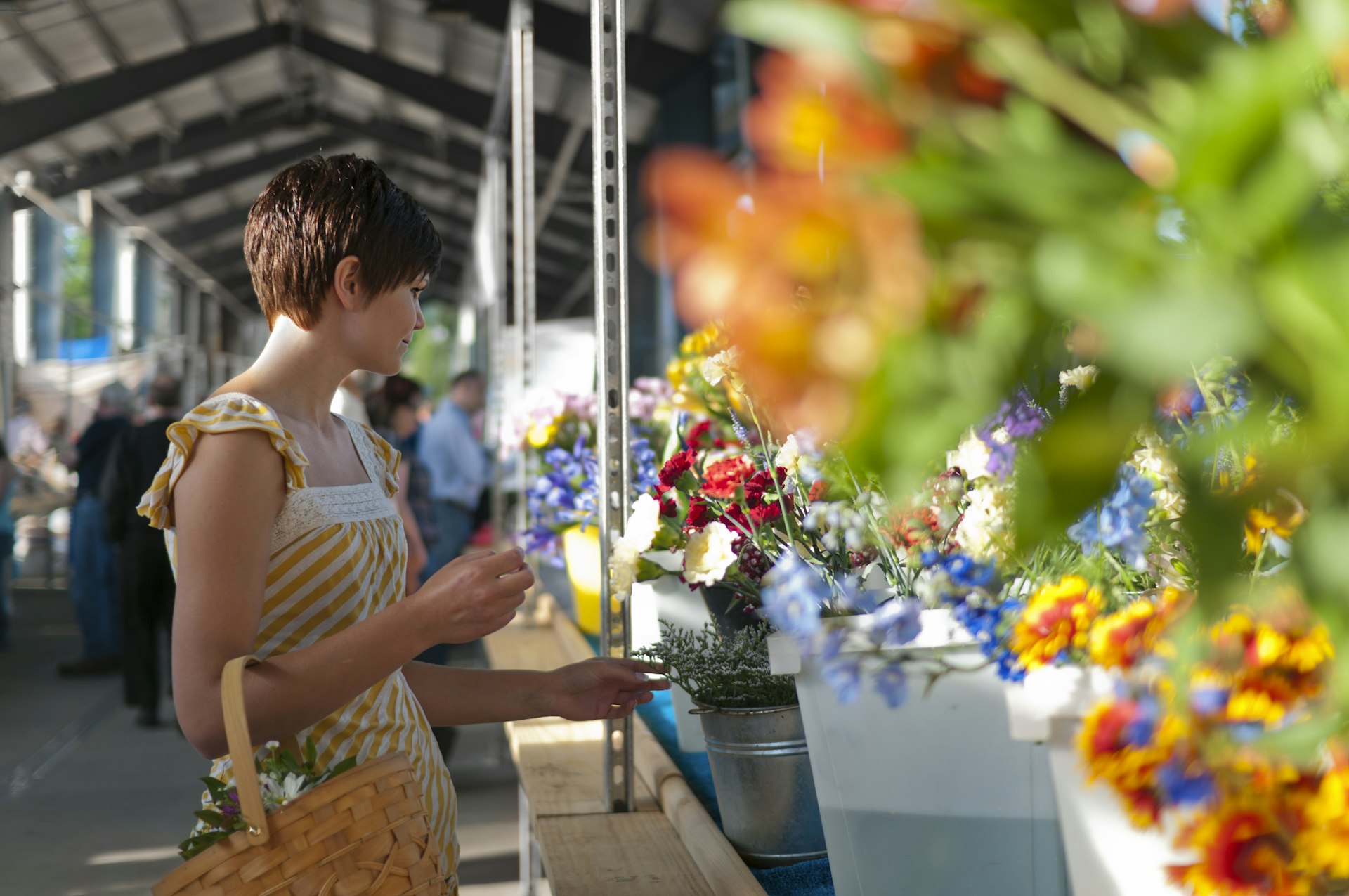 Young woman shopping for flowers at a farmers market