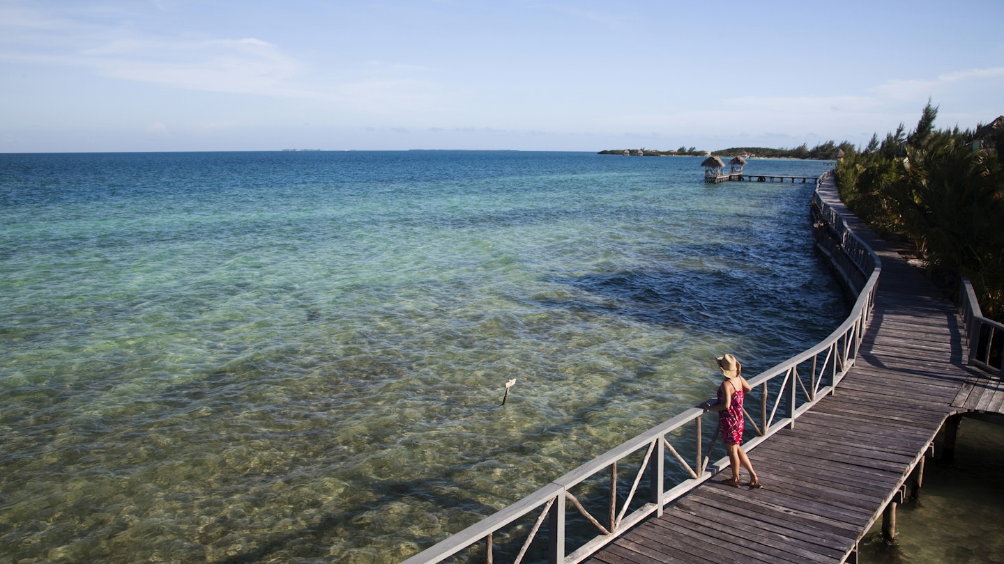 THATCH CAYE, BELIZE. A woman wearing a red sun dress walks on a wooden pier over crystal clear water and a blue sky above.
564189675
40-44 Years, 40s, Adult, belize, Boardwalk, Central America, color image, Copy Space, day, Full Length, Getting Away From It All, Horizon Over Water, Horizontal, idyllic, latin america, Looking At View, Mature Adult, Mature Women, One Person, outdoors, photography, Rear View, relaxation, Sea, Selective Focus, Sky, sundress, Thatch Caye, travel, Travel Destinations, Tropical Climate, Vacations, water, women, wood