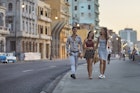 Young friends walking on sidewalk during sunset in Havana. Happy male and females are enjoying vacation. They are wearing casuals.
914846138