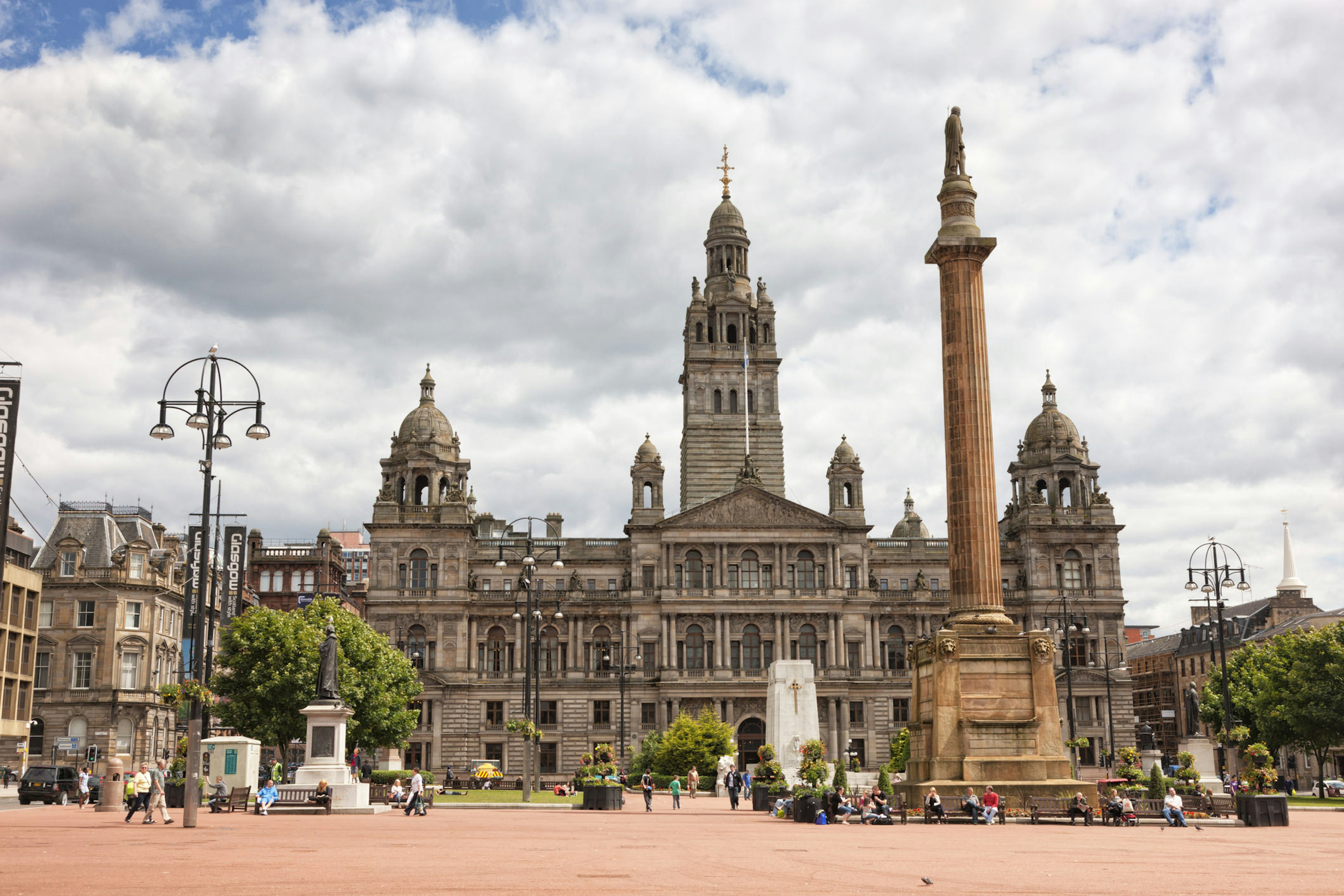 An ornate building on Glasgow's George Square with people milling about.