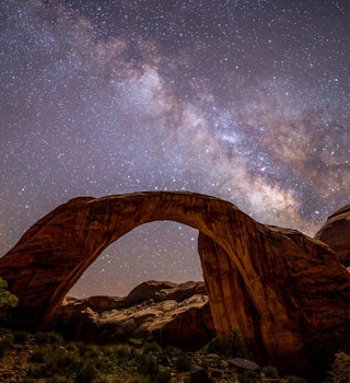 Rainbow Bridge National Monument at night with the Milky Way.
987832576
No People, Day, Tranquil Scene, Sky, Rock, Outdoors, USA, Nature, Landscape - Scenery, Desert, Color Image, Cloud - Sky, Scenics - Nature, Horizontal, Rock - Object, Mountain, Dramatic Sky, Beauty In Nature, Sunset, Sunlight, Photography