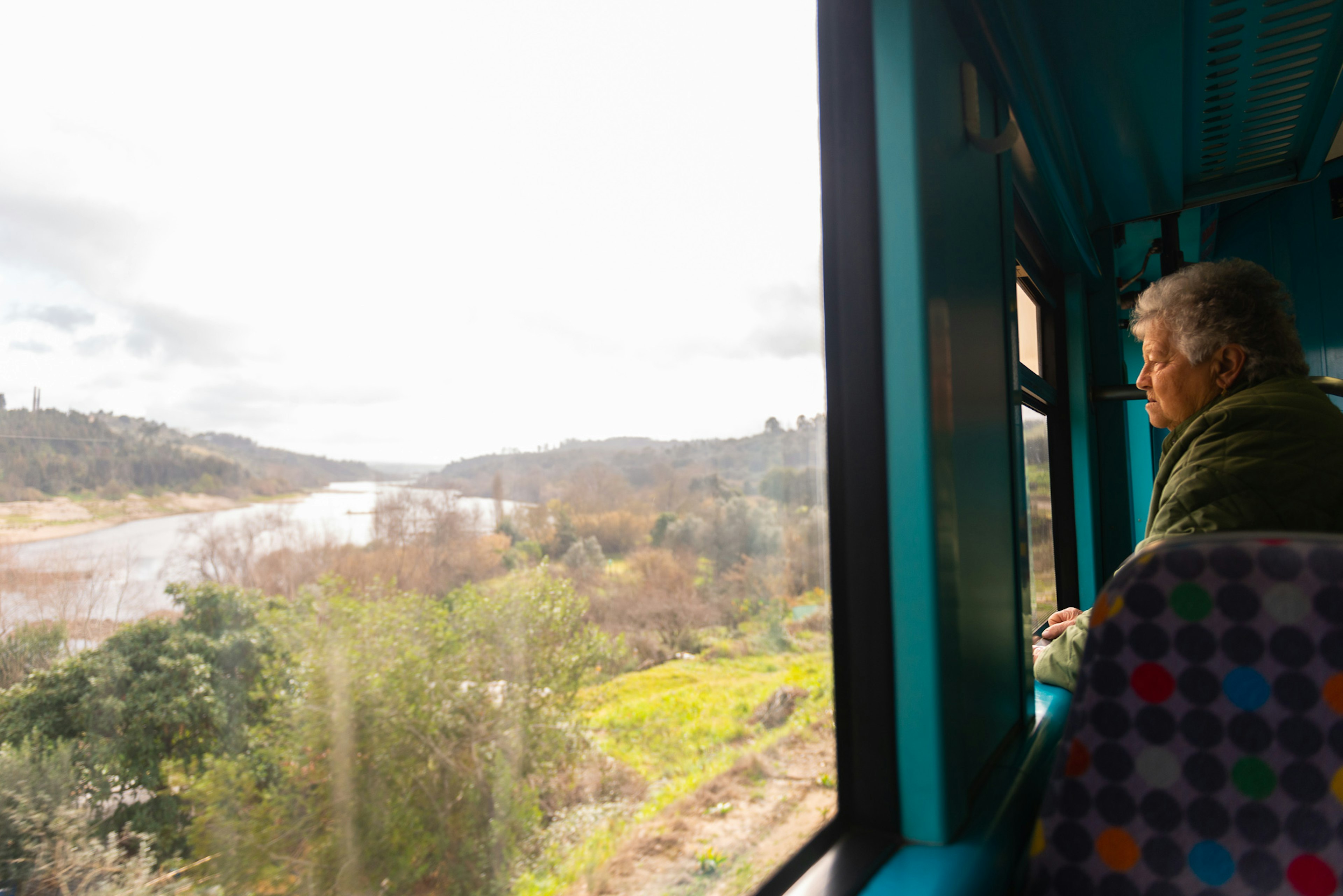 A passenger looks from a train window out at the Tagus River, Portugal