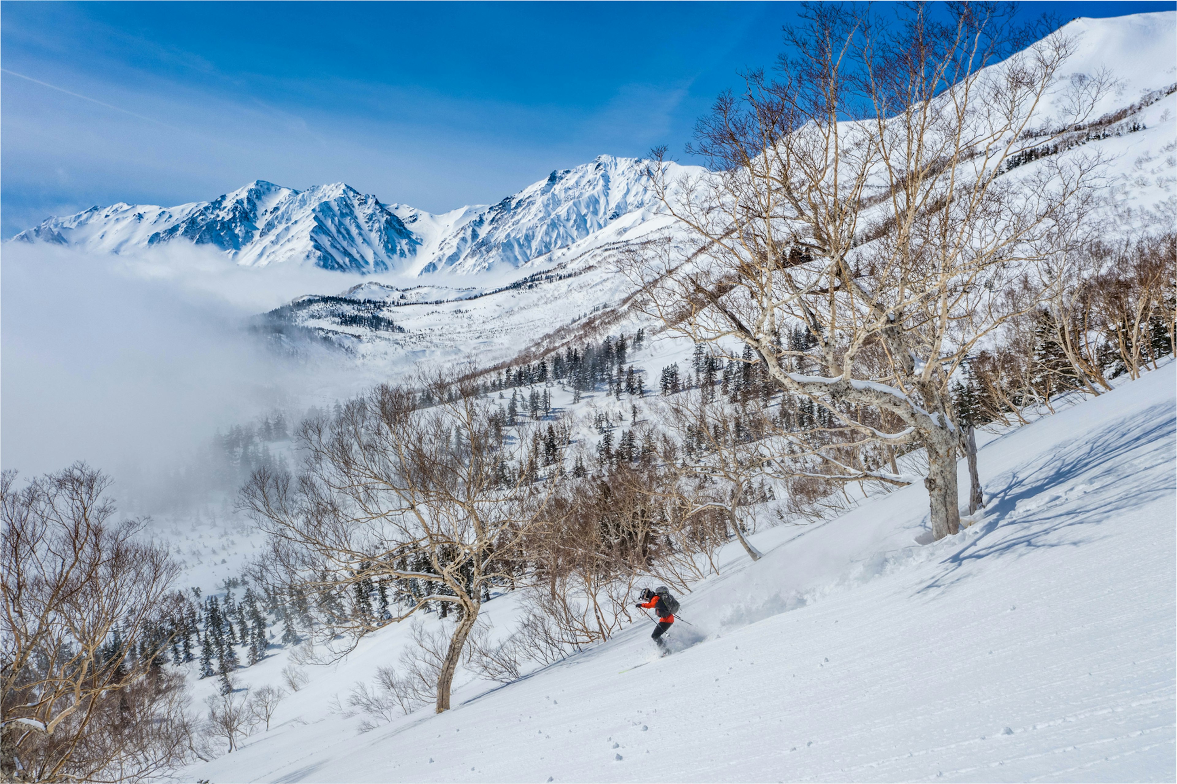 Skiing through the Japanese alps on a beautiful sunny day after heavy snowfall