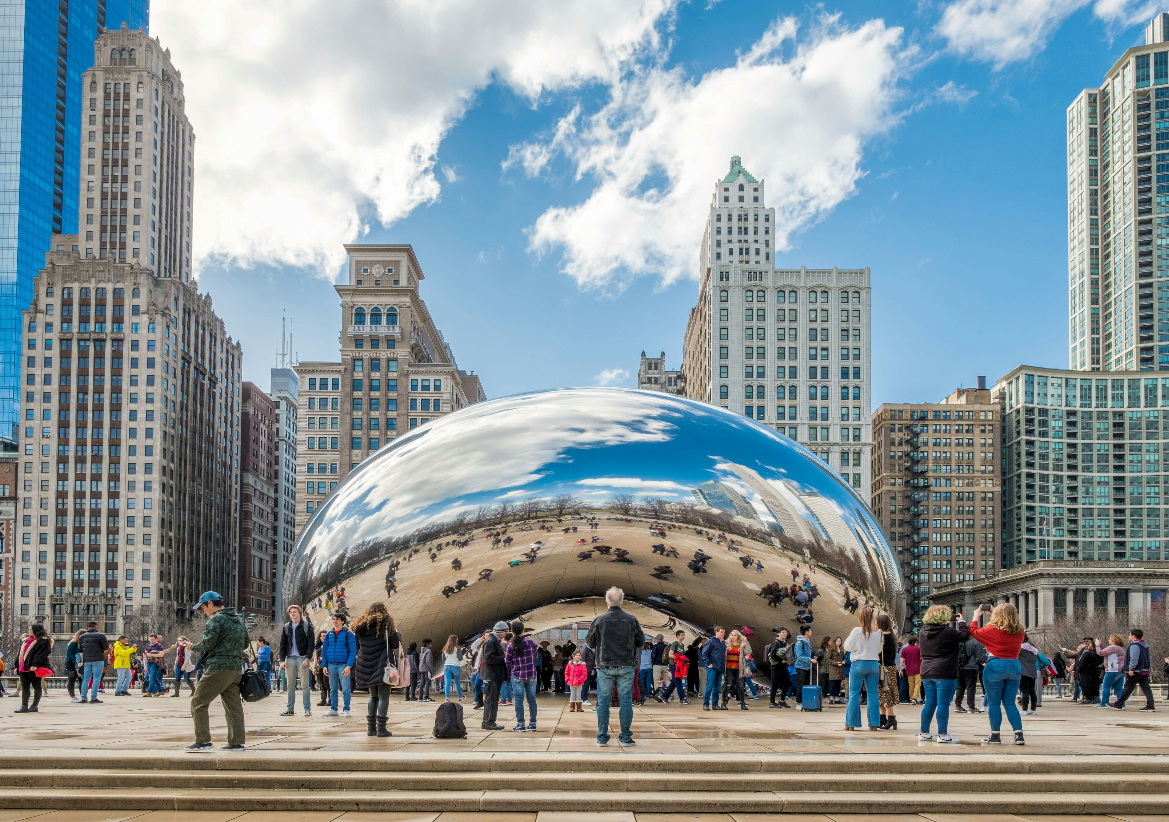 Tourists admire iconic Cloud Gate at Millenium Park during early spring.