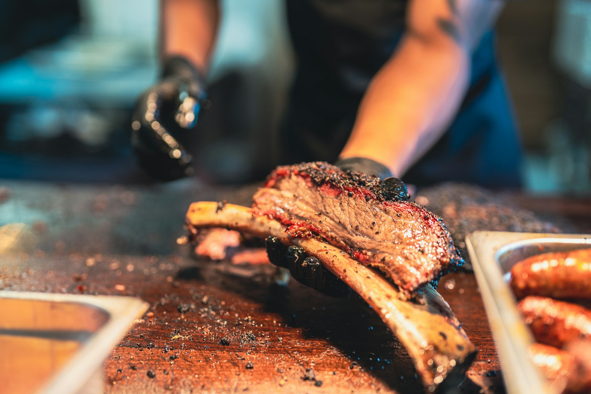 A Texas BBQ chef holding a portion of smoked brisket 