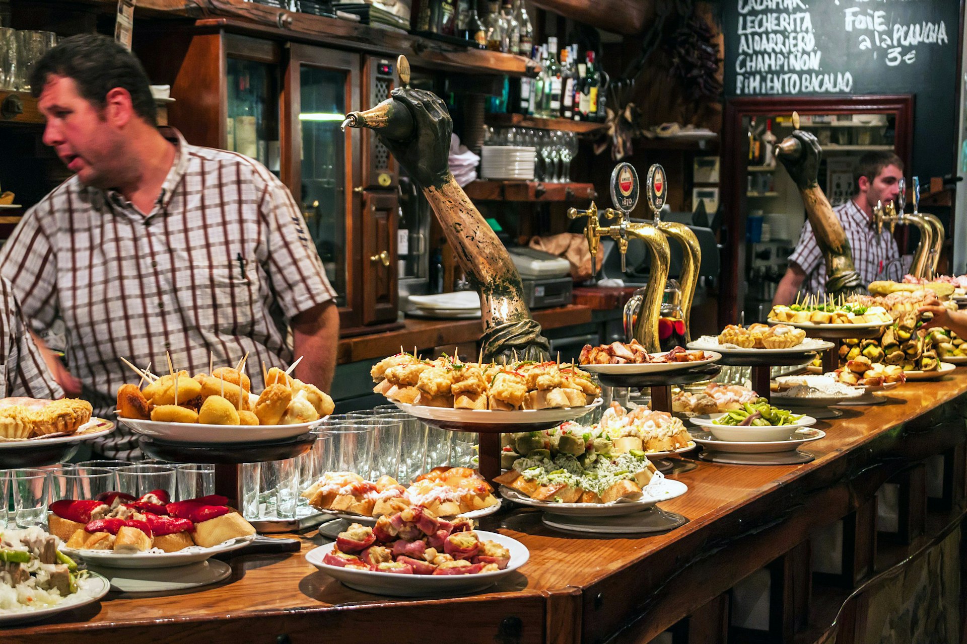 A bar with plates full of traditional pintxos - small snacks - on display