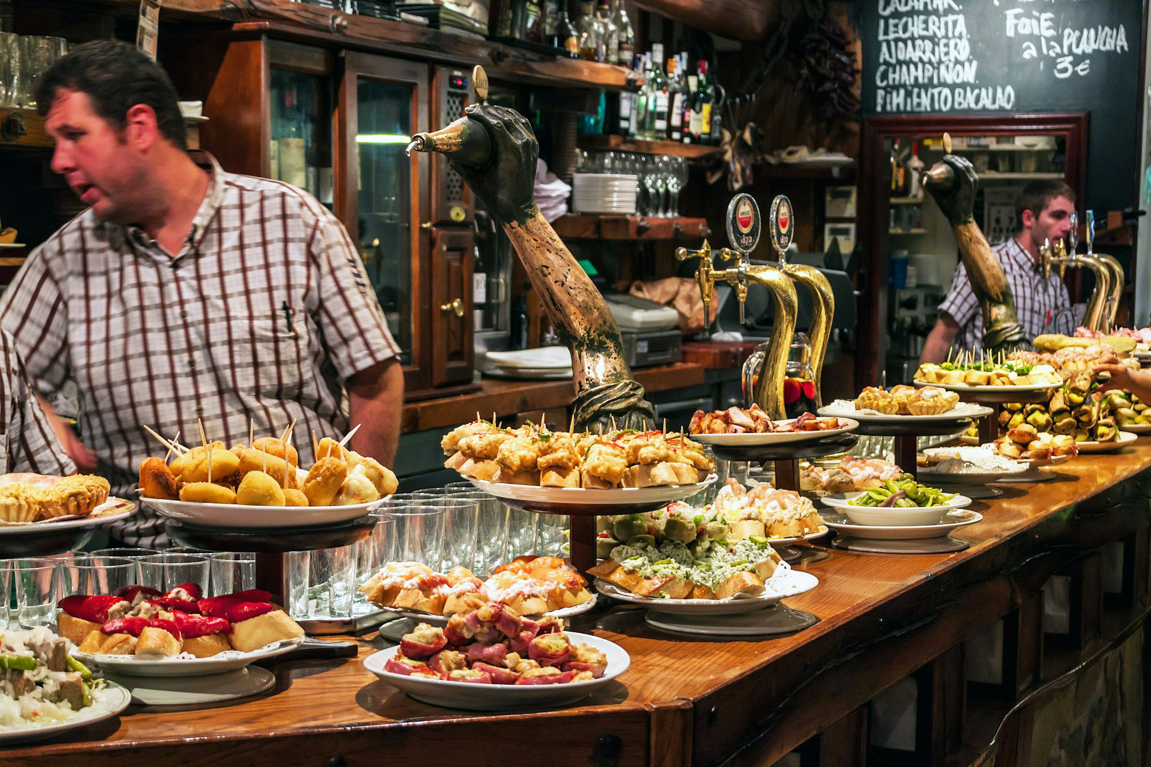 The Best Foodie Destinations for Culinary Travel A bar with plates full of traditional pintxos - small snacks - on display