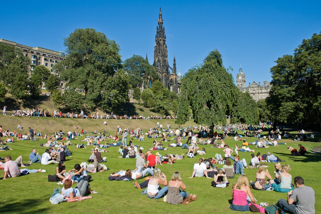 Princes street garden with Scott Monumentfull of people in a sunny summer day.