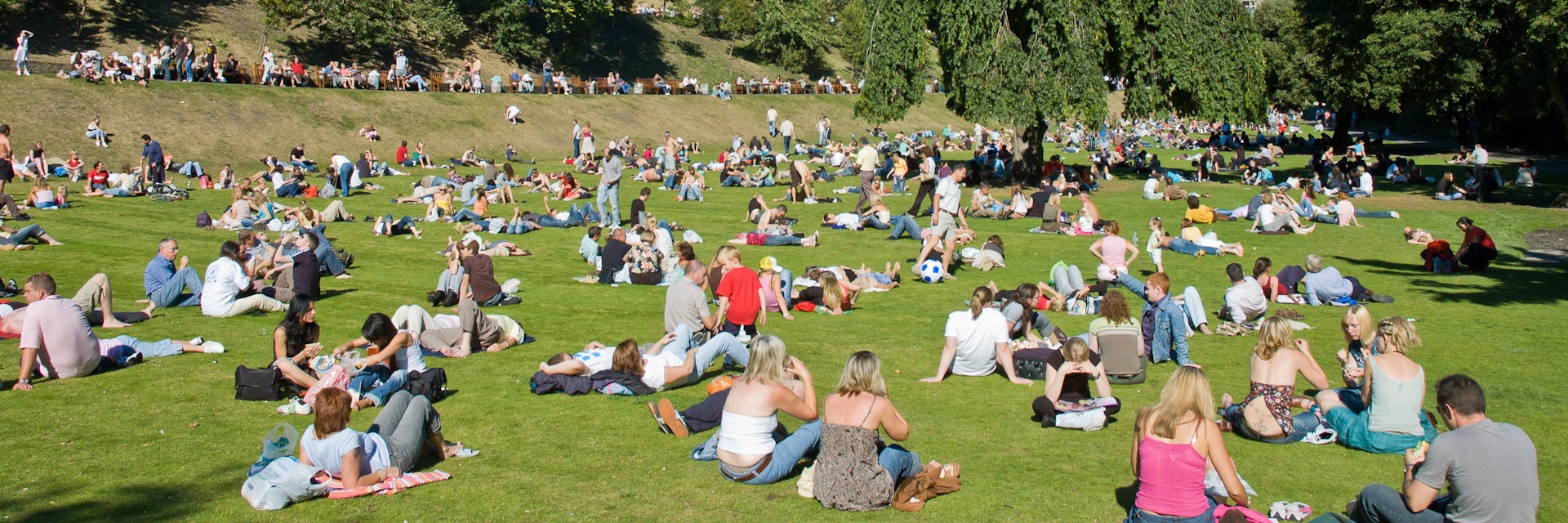 Princes street garden with Scott Monumentfull of people in a sunny summer day.