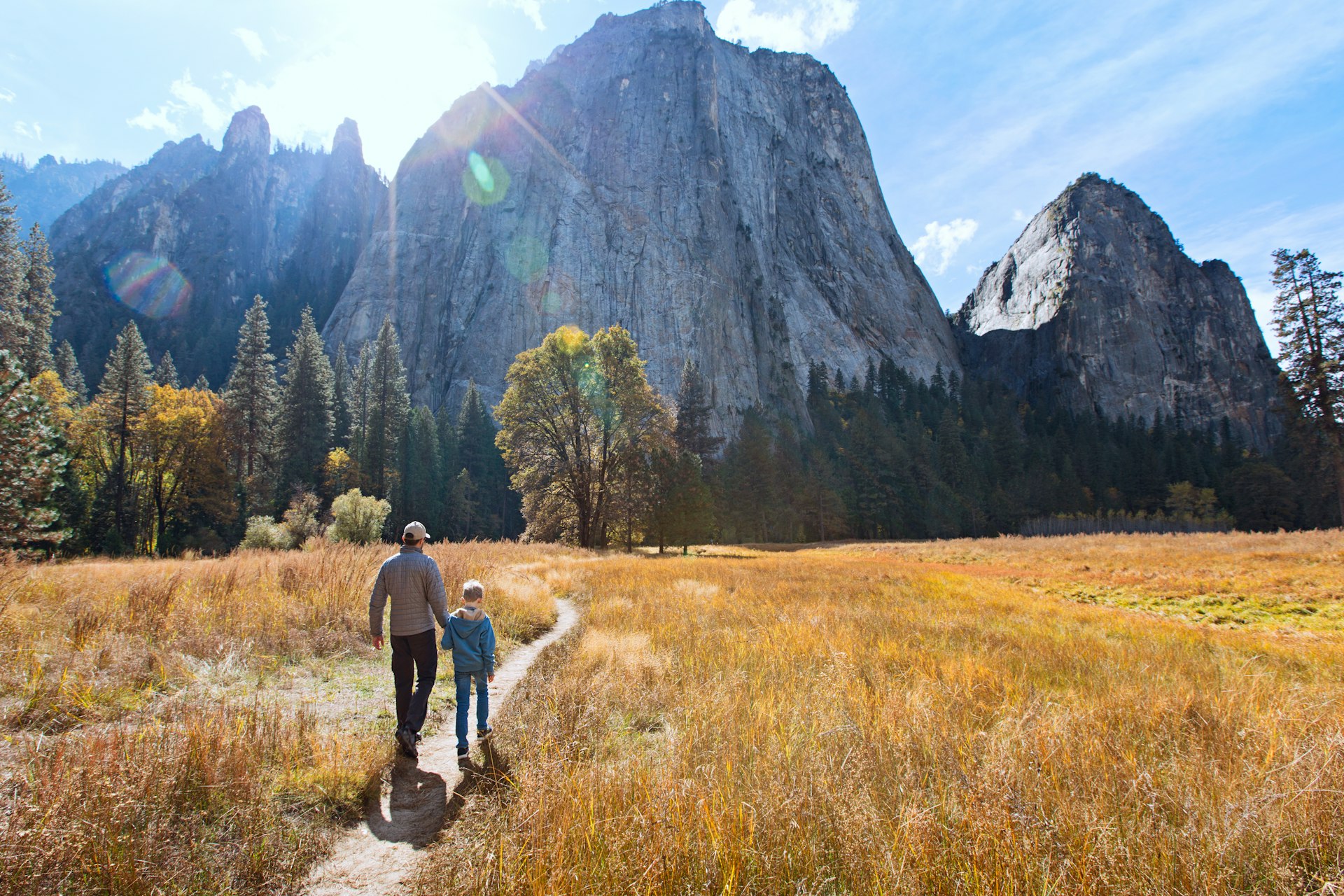 Back view of active family of two, father and son, enjoying valley and mountain view in Yosemite National Park, California