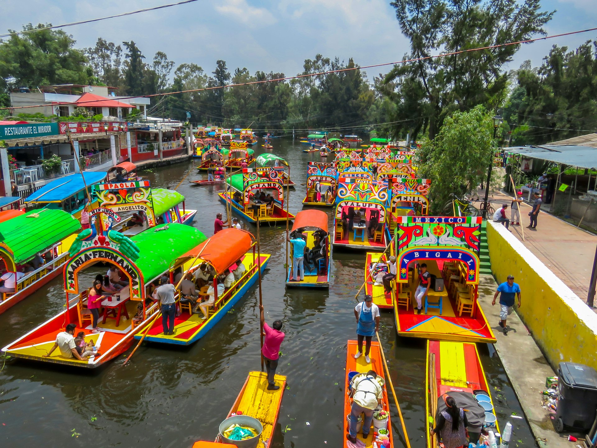 Dozens of brightly painted trajinera gondolas wait to take passengers in the canals of Xochimilco, Mexico City, Mexico