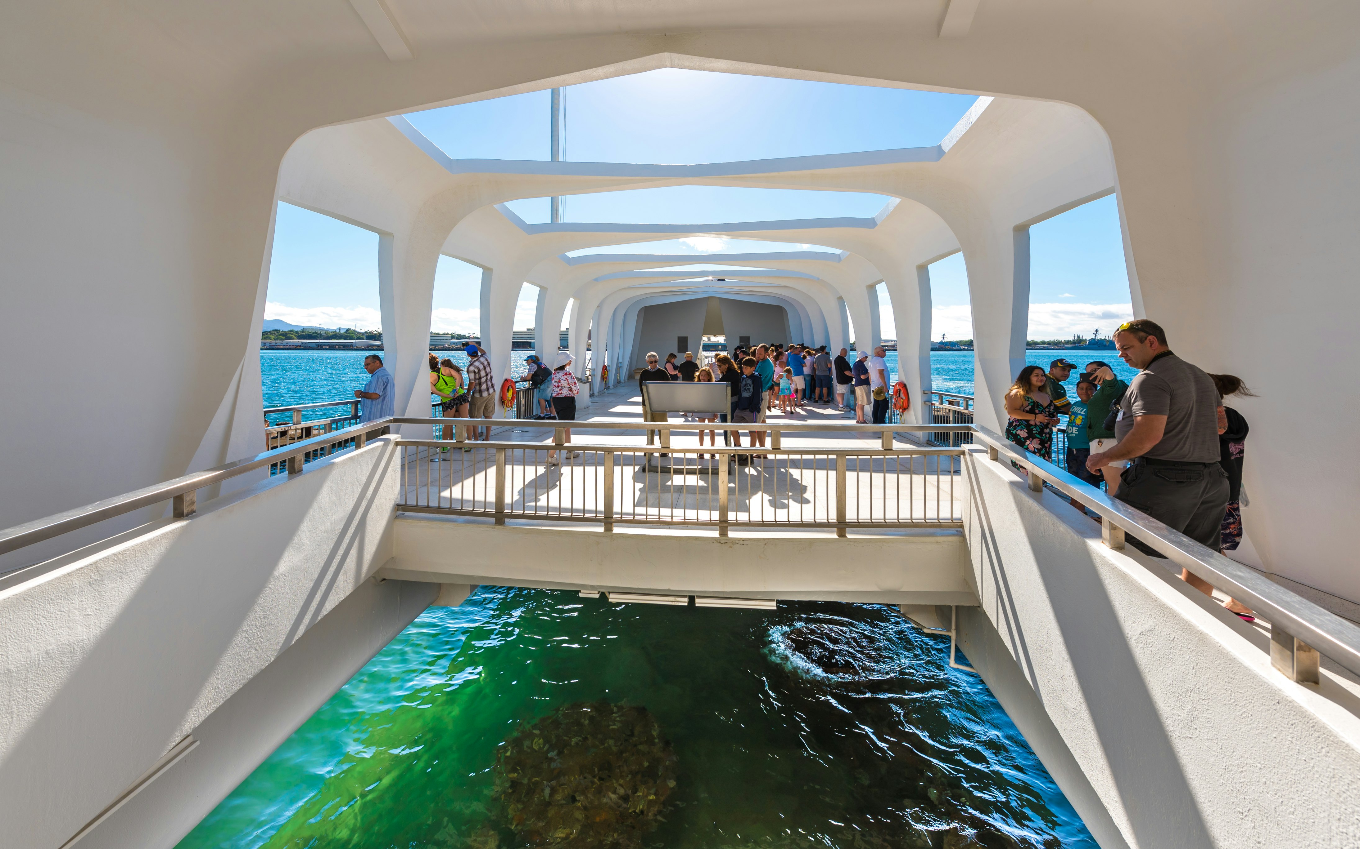 The USS Arizona Memorial straddles the sunken hull of the battleship without touching it.