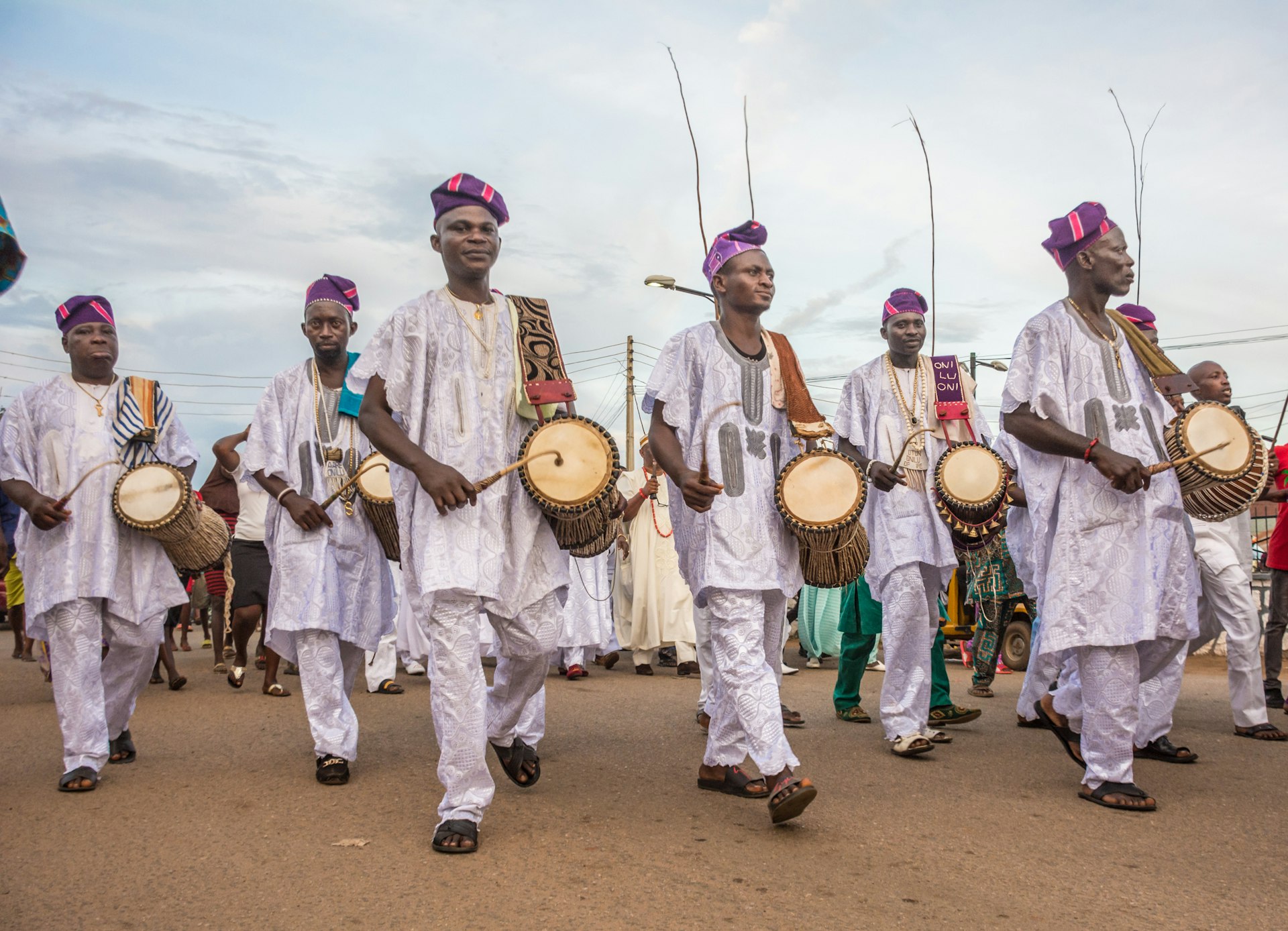 Drummers wearing white perform in the street