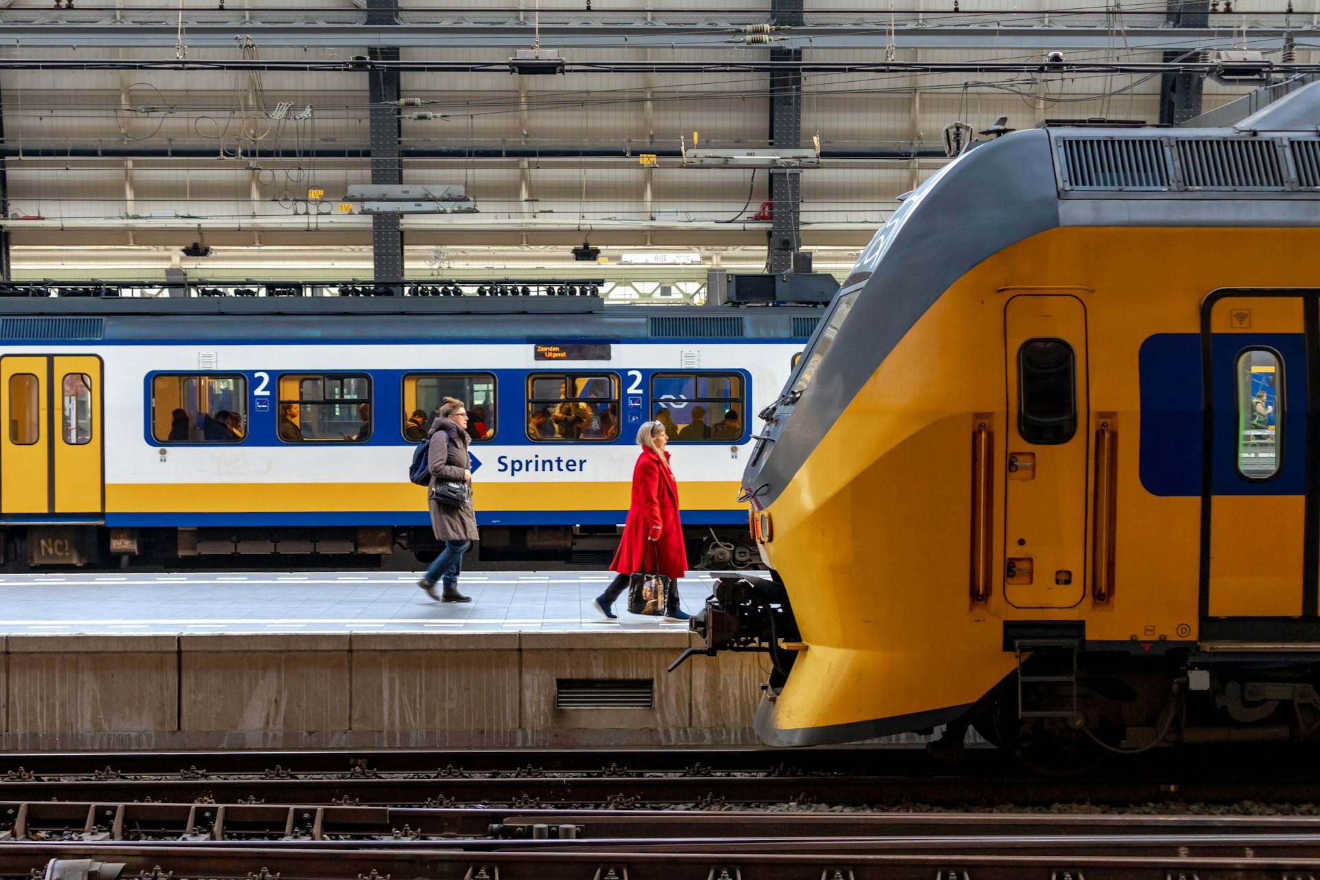 Amsterdam centraal train station with people traveling by train and sprinter, NS Intercity train at the main station