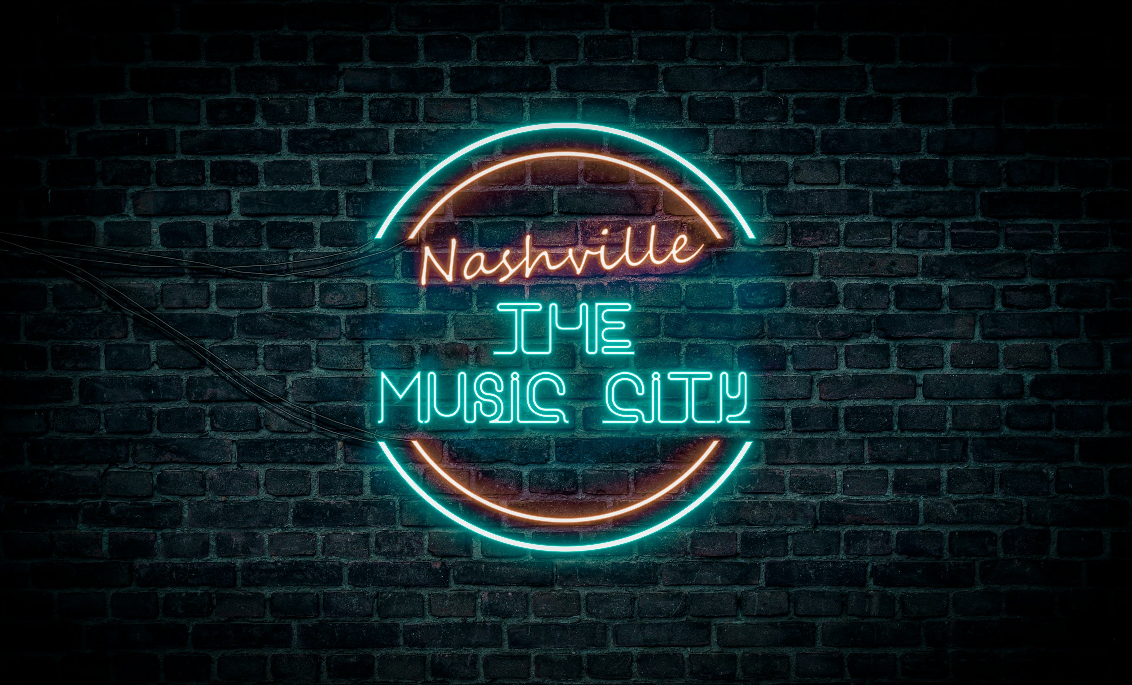 A red and blue neon light sign that reads Nashville the Music City