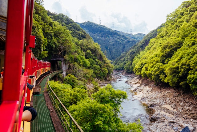The world-famous Sagano Romantic Train running along the gorge formed by the Katsura River near Kyoto, Japan