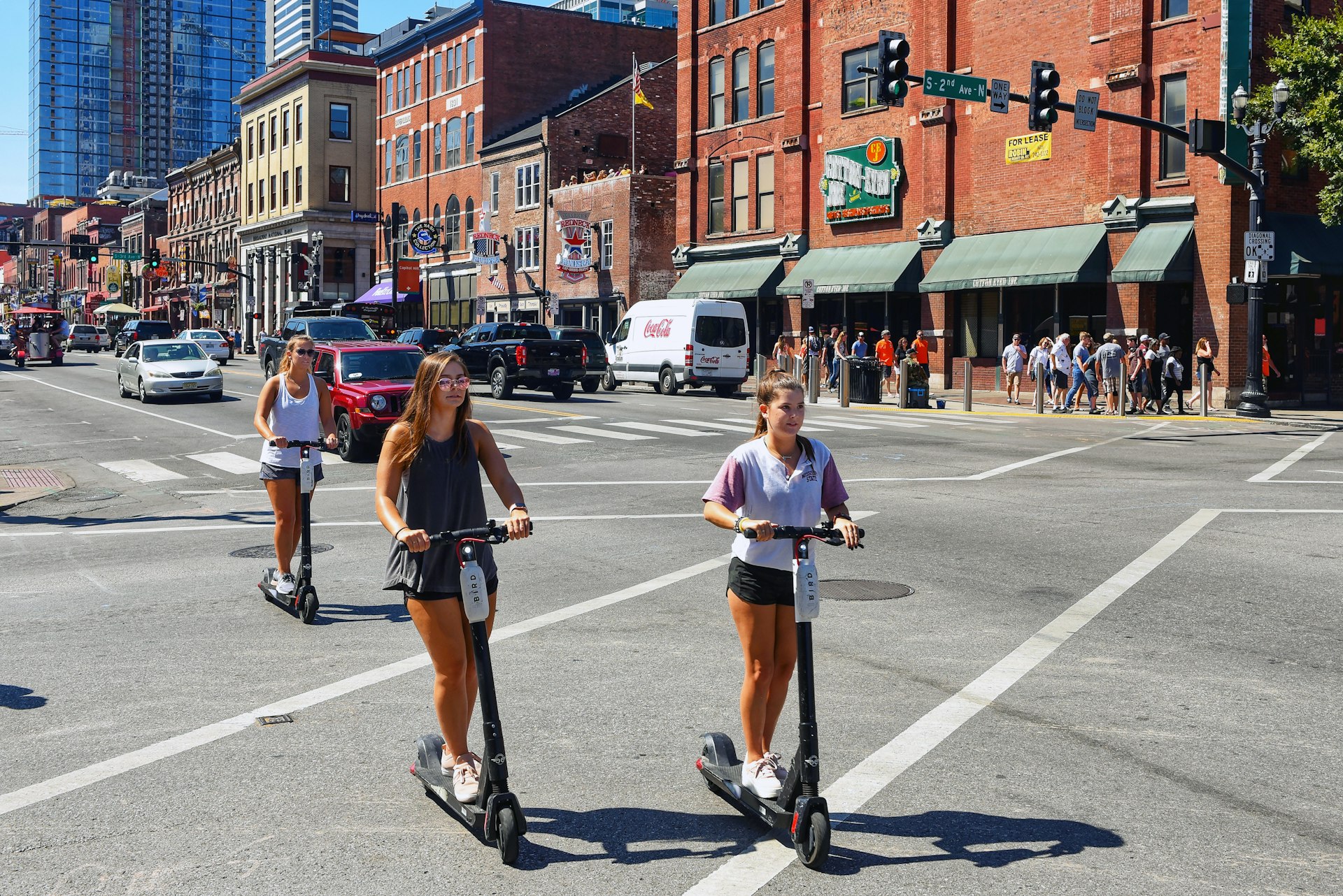 Young women ride rental scooters on Broadway Street. Scooter sharing is popular in Nashville