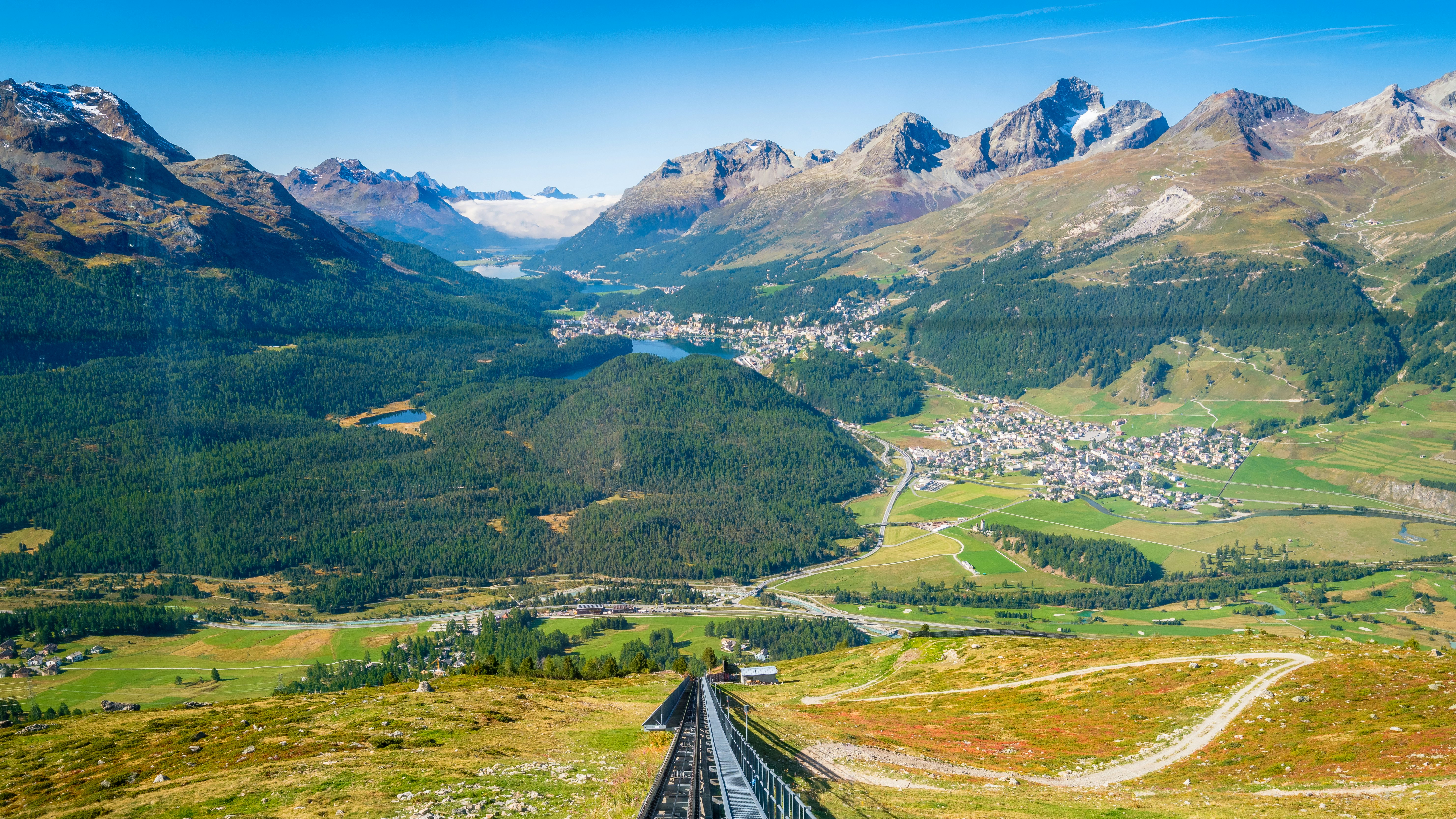 View of Celerina, the Upper Engadine Valley and the four Upper Engadine Lakes from inside the Mouttas Muragl Bahn funicular train, waiting at the top station Muottas Muragl.