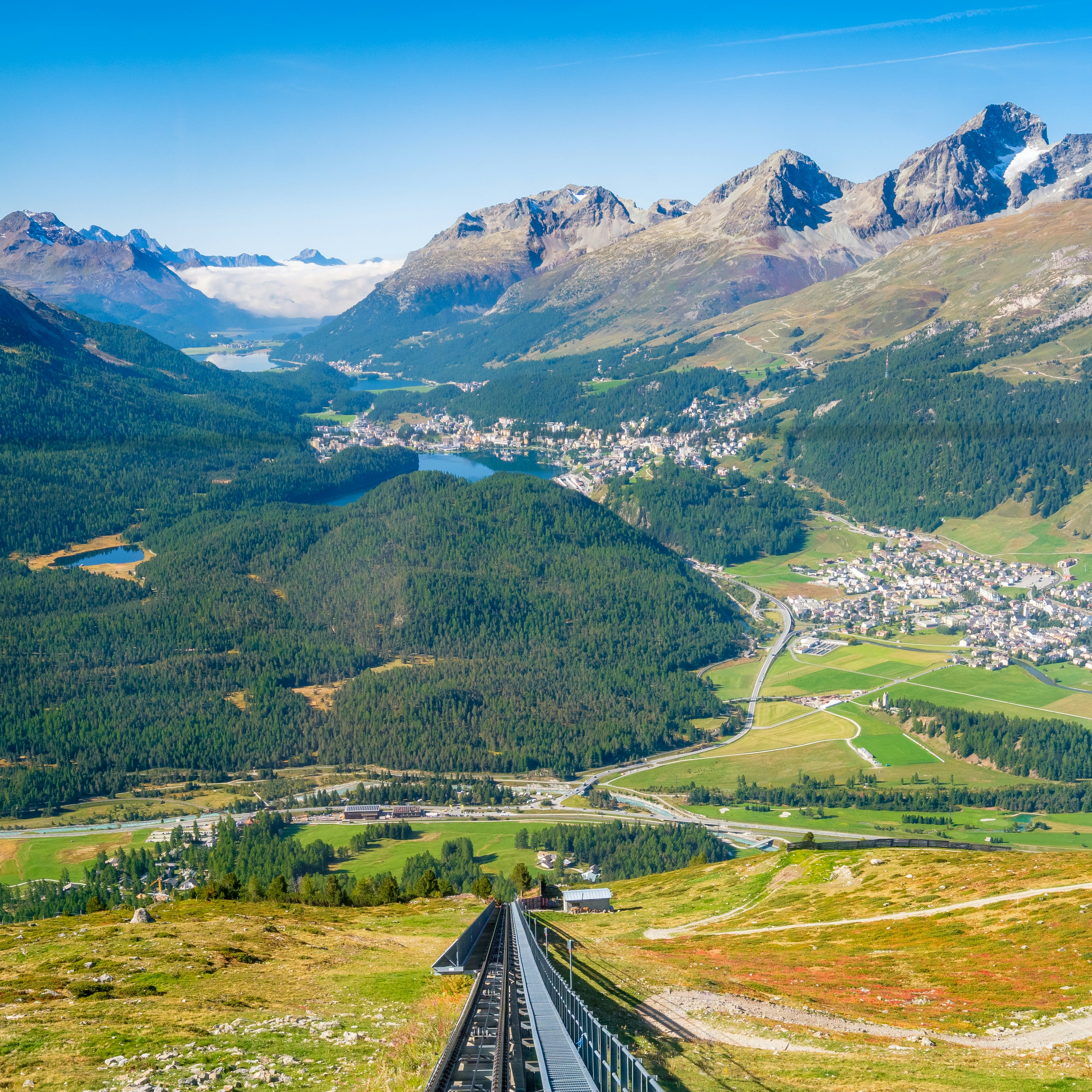 View of Celerina, the Upper Engadine Valley and the four Upper Engadine Lakes from inside the Mouttas Muragl Bahn funicular train, waiting at the top station Muottas Muragl.
