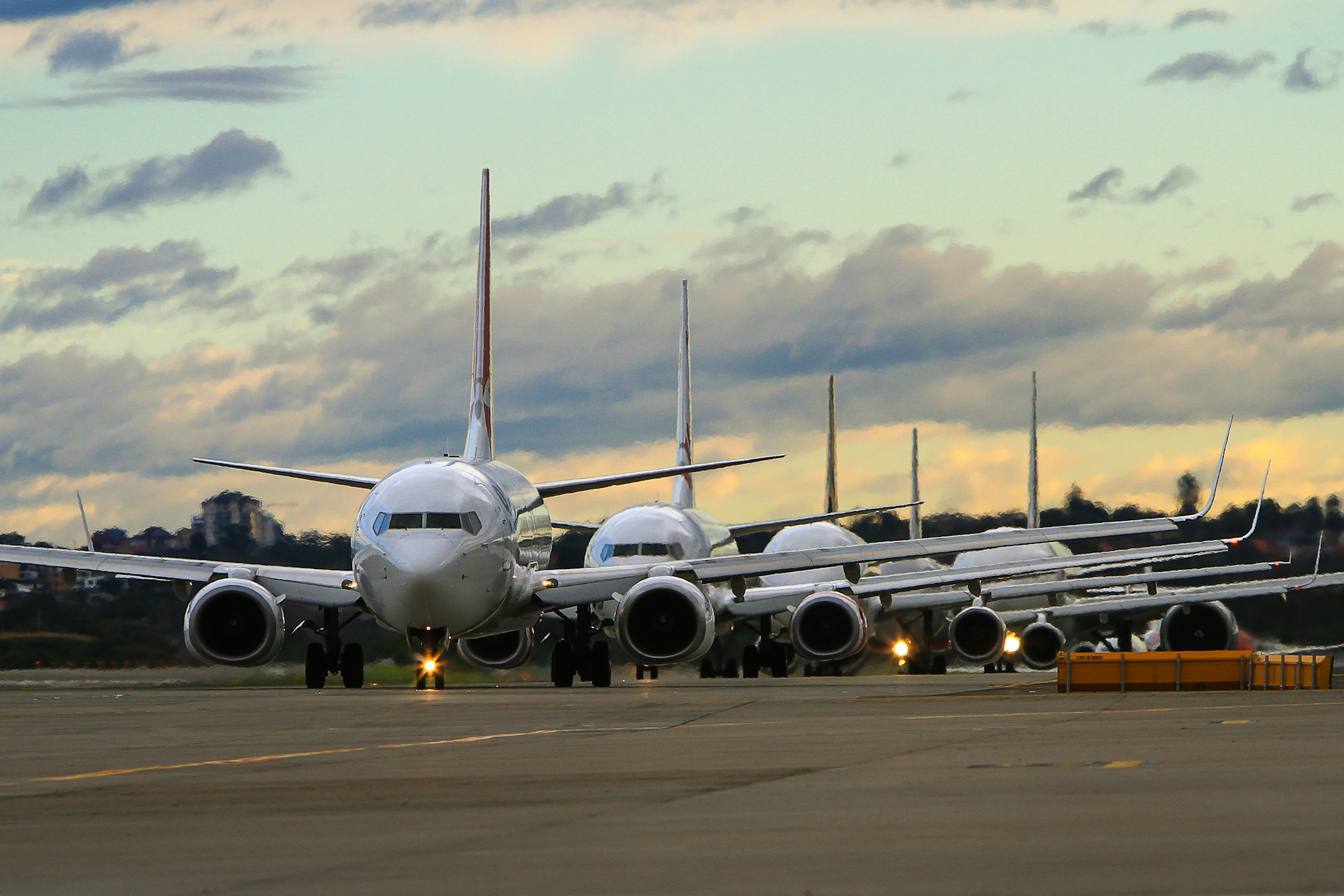 Jet airplanes lined up at dusk on runway