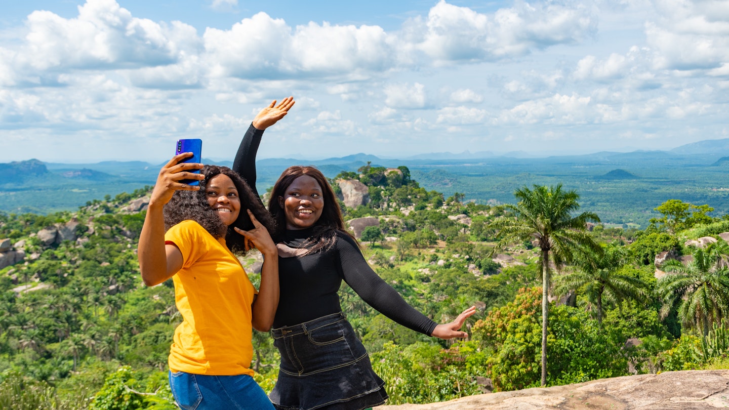 young female african friends standing together outdoor on a hike through nature taking selfies; Shutterstock ID 2043041669; your: Claire Naylor; gl: 65050; netsuite: Online ed; full: Nigeria best places
2043041669